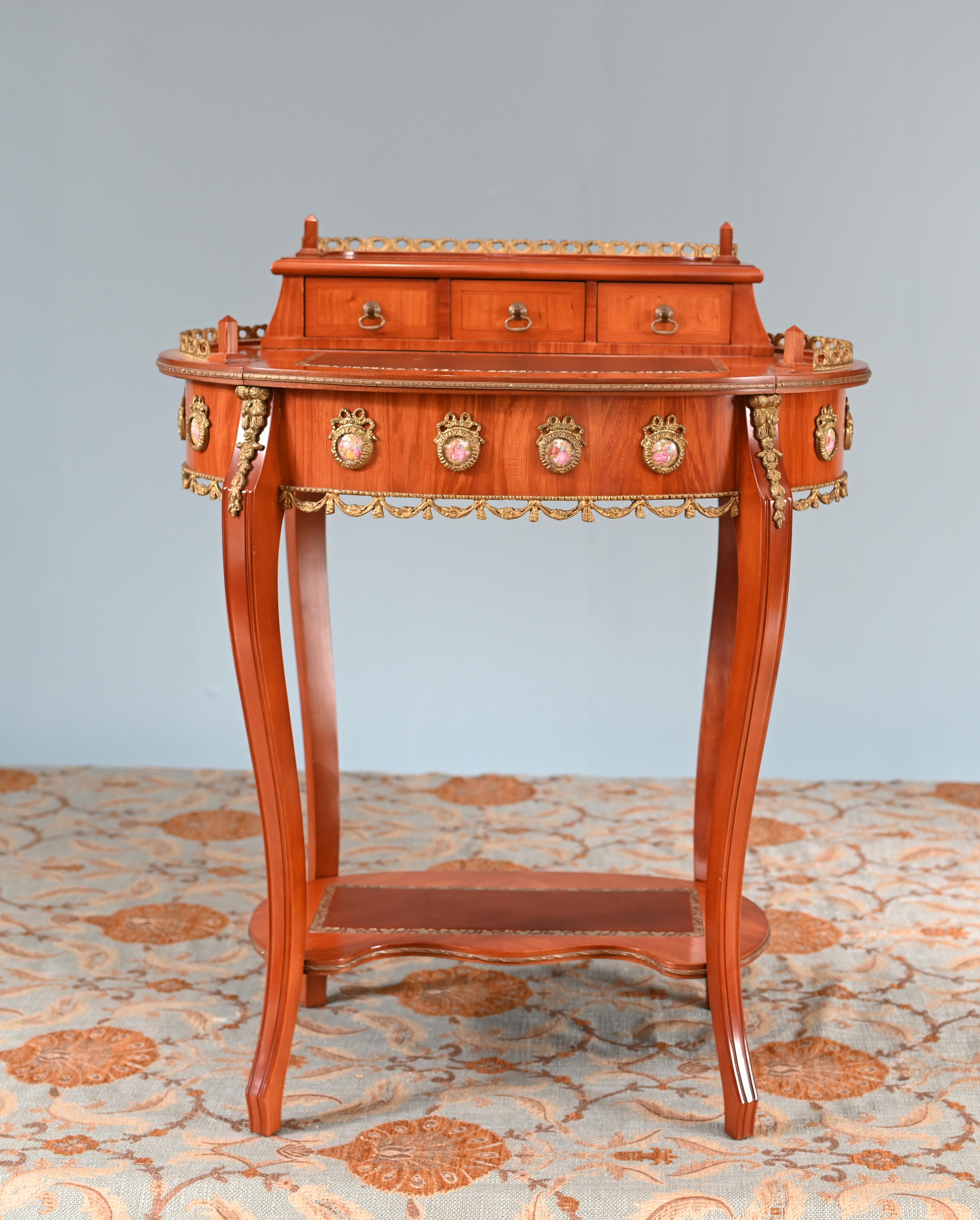 Prachtvoller französischer Damenschreibtisch mit Ormolu-Beschlägen und Sèvres-Plaketten
um 1930 und handgefertigt aus Königsholz
Schreibfläche aus bordeauxfarbenem Leder mit Goldprägung
Porzellanplatten aus Sèvres mit romantischen Szenen
Gekauft bei