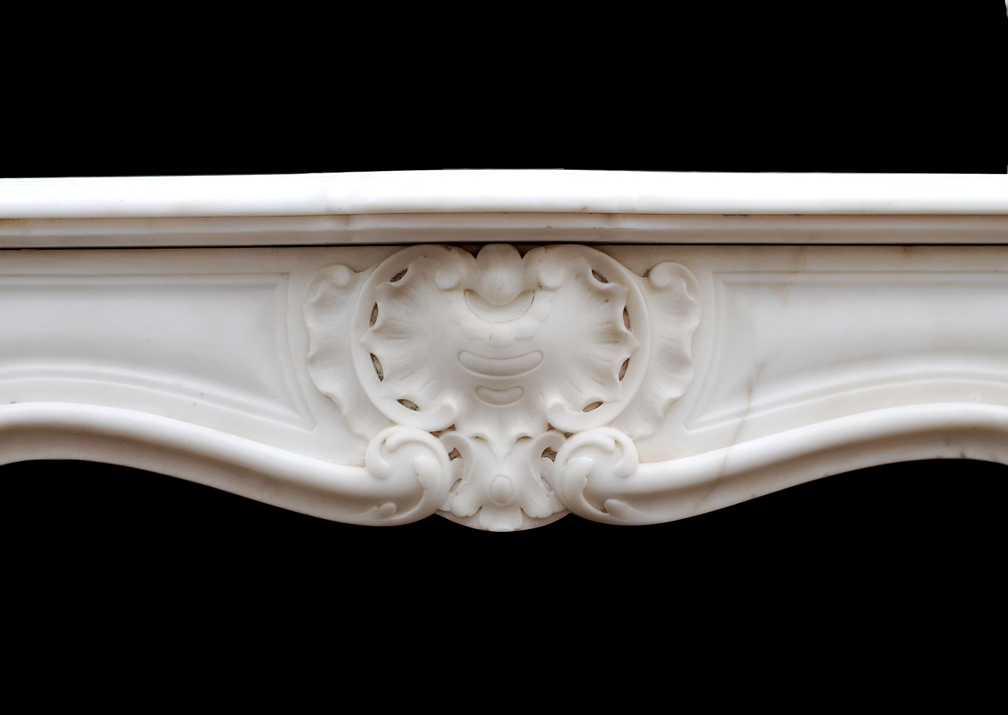 An unusually small French 19th century Louis XV style Statuary marble fireplace with carved centre to frieze and fluted shaped jambs surmounted by scrolls. Recommended for a small bedroom.

Measure: 
Shelf Width:	940 mm      	37 in
Overall
