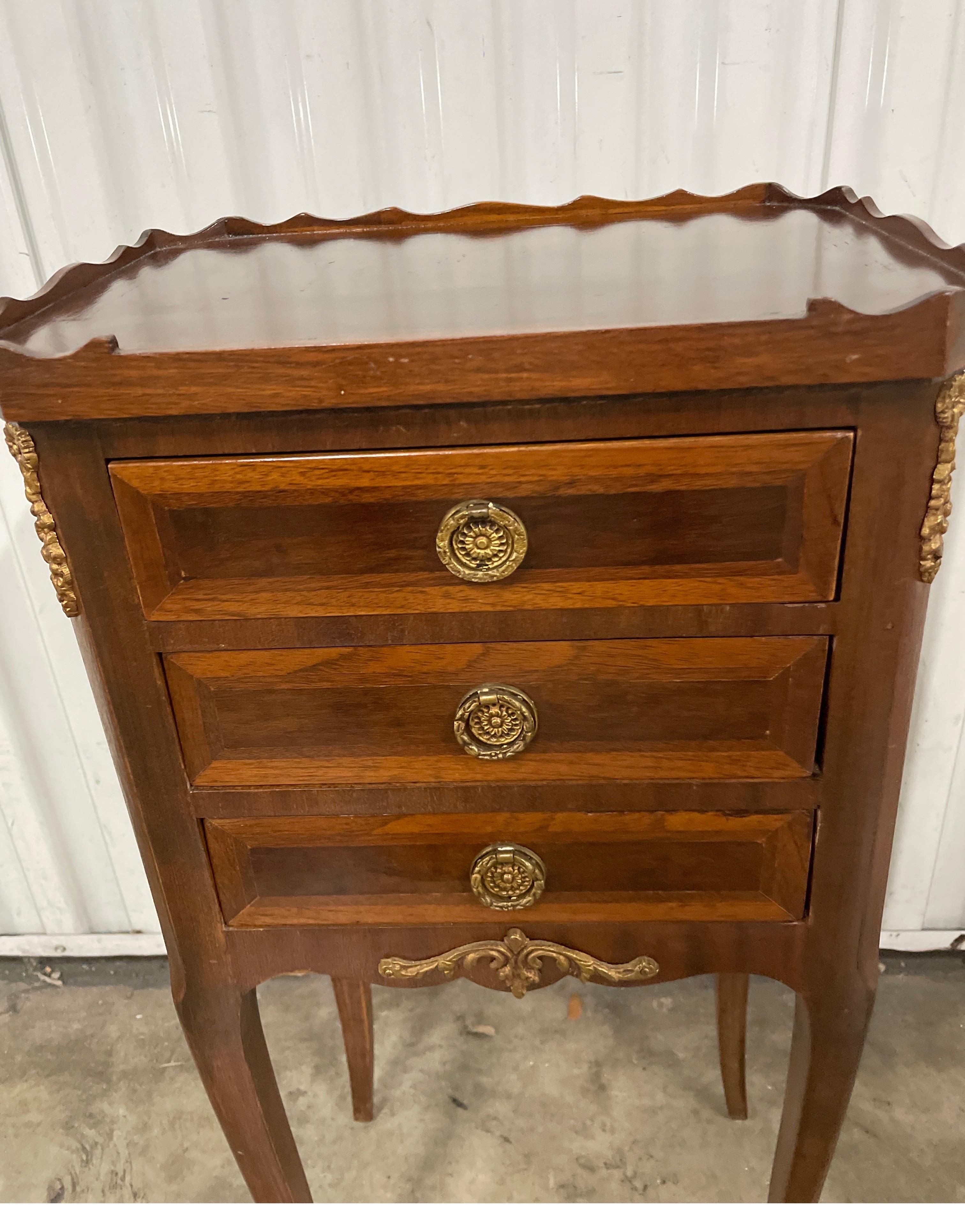 French Louis XV style petite three drawer chest with ormolu trim. Top has a scalloped edge Very nice inlaid details. Perfect little side table / drinks table.