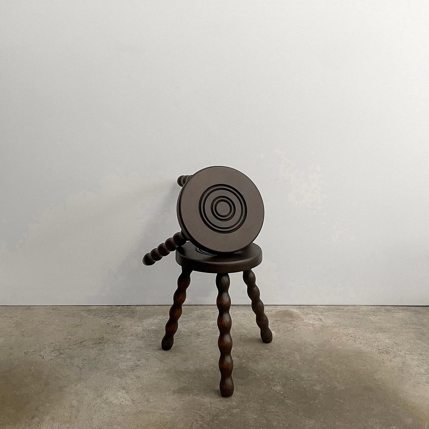 Tabouret tripode en chêne français
France, milieu du siècle
Siège circulaire en bois massif avec cercles concentriques sculptés 
Pieds de trépieds en bois tourné fantaisistes
Joli détail de grain
Légères fissures sur l'assise en bois, mais