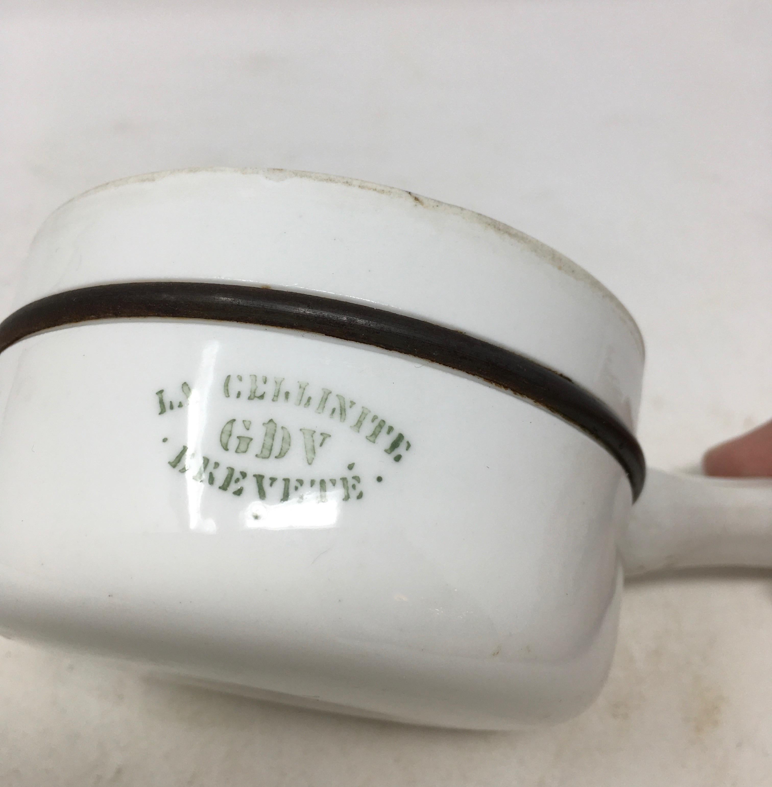 This petite French sauce pan is made of metal and porcelain. The porcelain is marked La Cellinite GDV Brevete, GDV is the mark for Girault, Demay and Vignelet, a company in central France specializing in the production of porcelain for laboratories