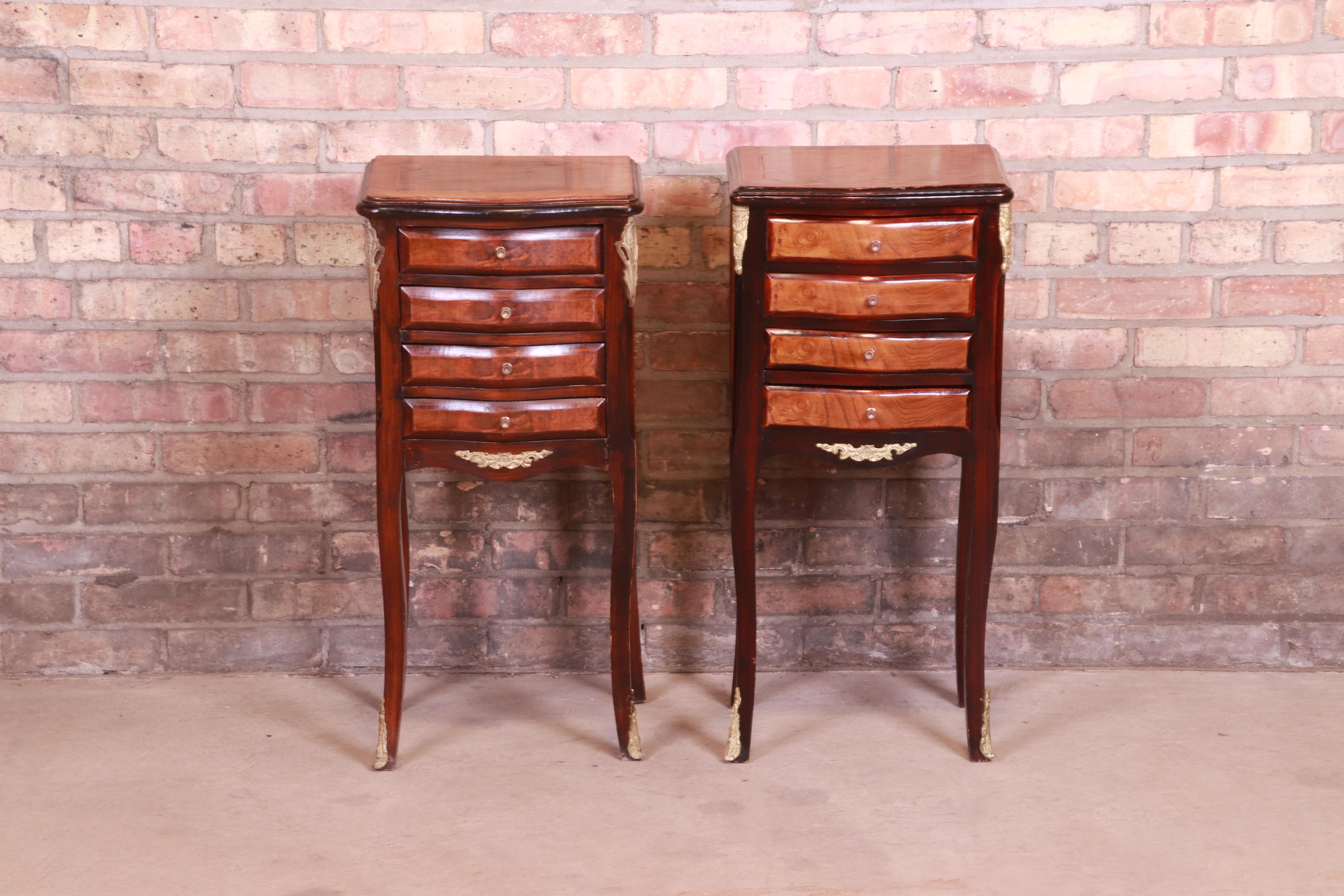 A gorgeous pair of petite French Provincial Louis XV style nightstands or end tables

France, Circa 1940s

Mahogany, with burl wood drawer fronts, satinwood inlay, and brass mounts and hardware.

Measures: 13.75