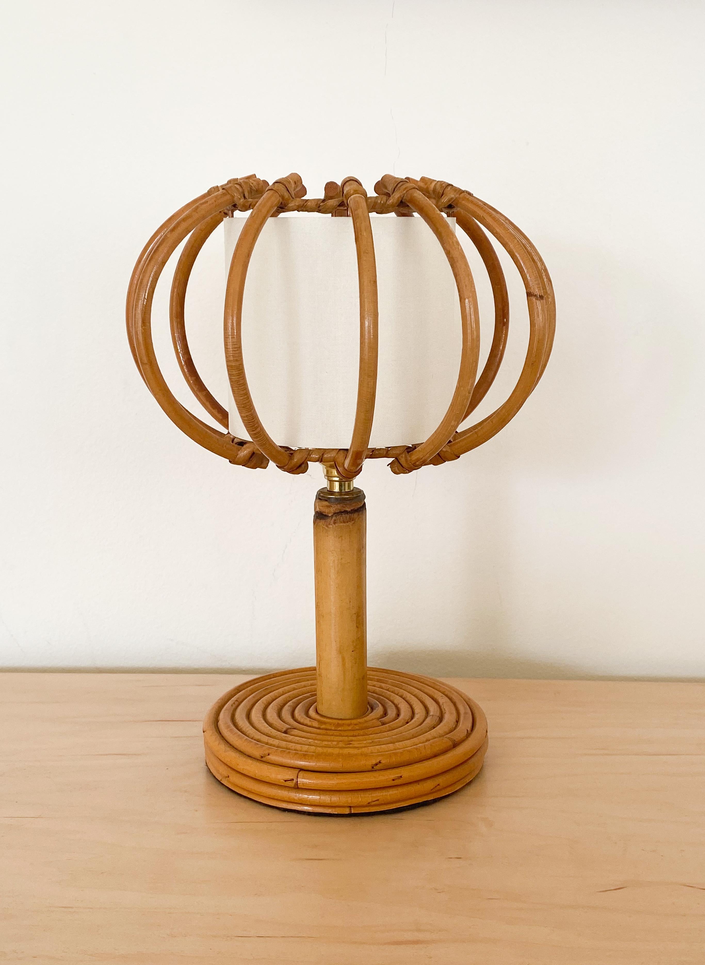 Petite French rattan table lamp with orb shaped shade. Circular base and rattan stem with rattan orb shaped shade and new silk interior shade lining. Newly re-wired. 



