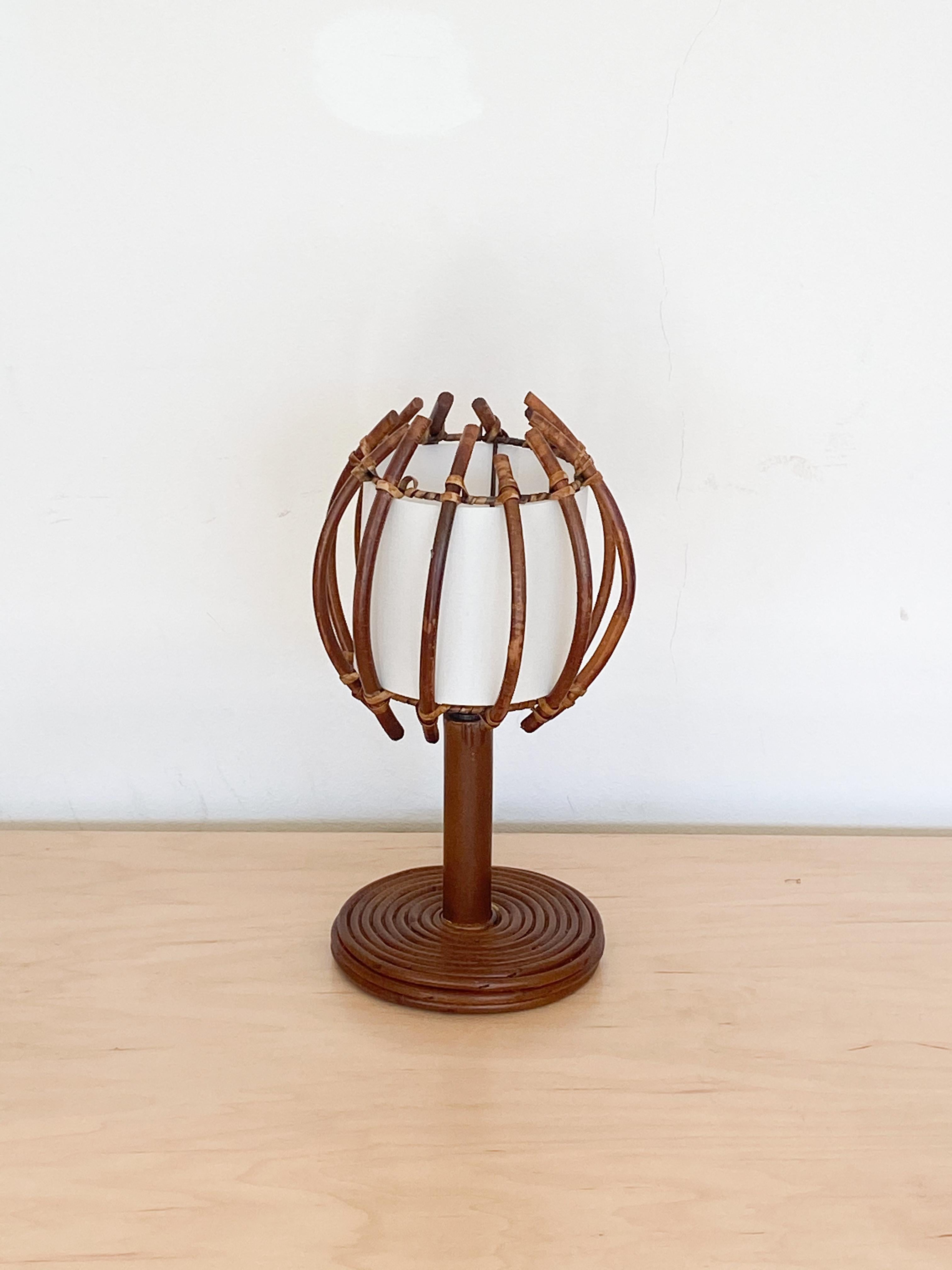 Petite French rattan table lamp with orb shaped shade. Circular base and rattan stem with rattan shade and new silk interior shade lining. Rattan has been newly refinished. Newly re-wired.



    