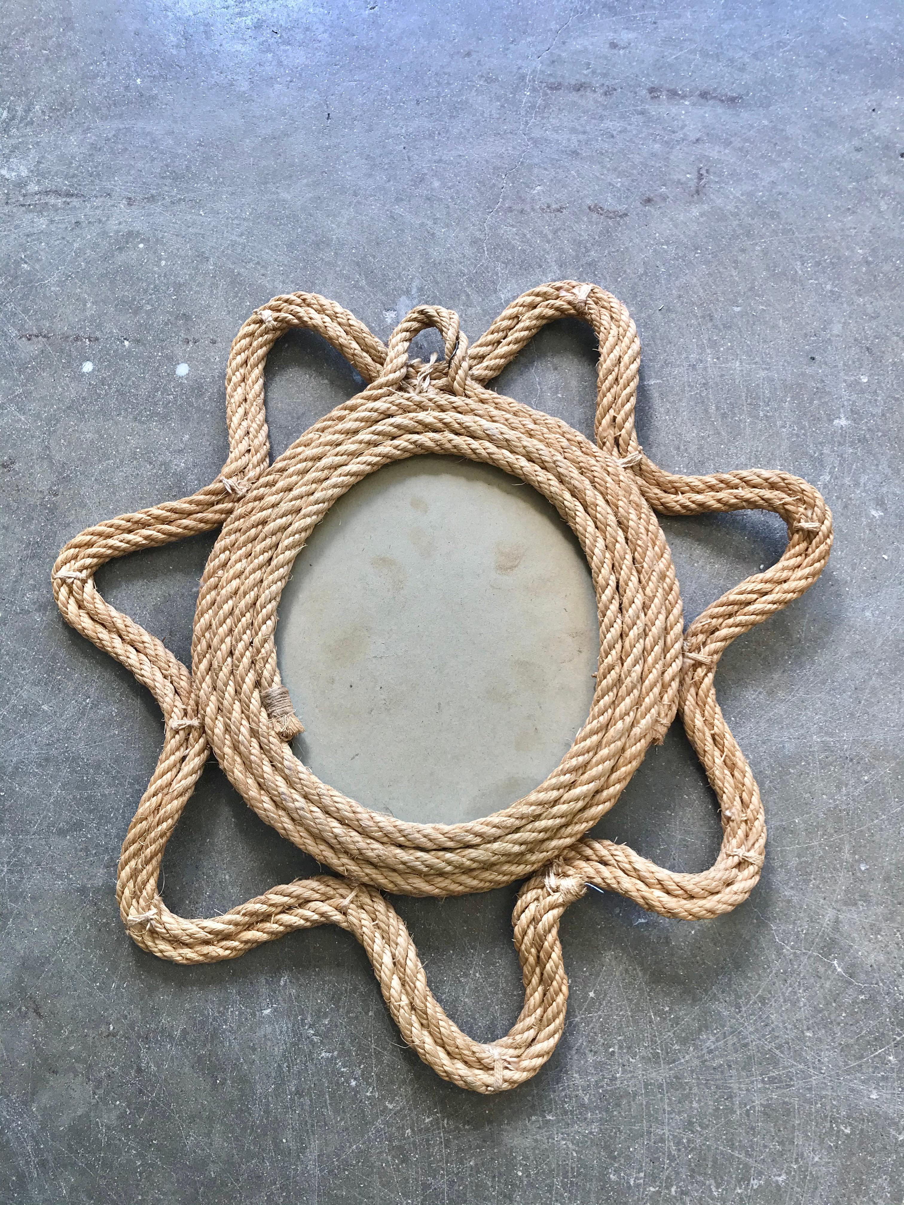 Handsome French mirror in the style of Audoux and Minet. Twisted rope frame in the shape of a starburst with a circular glass mirror. Great vintage condition.