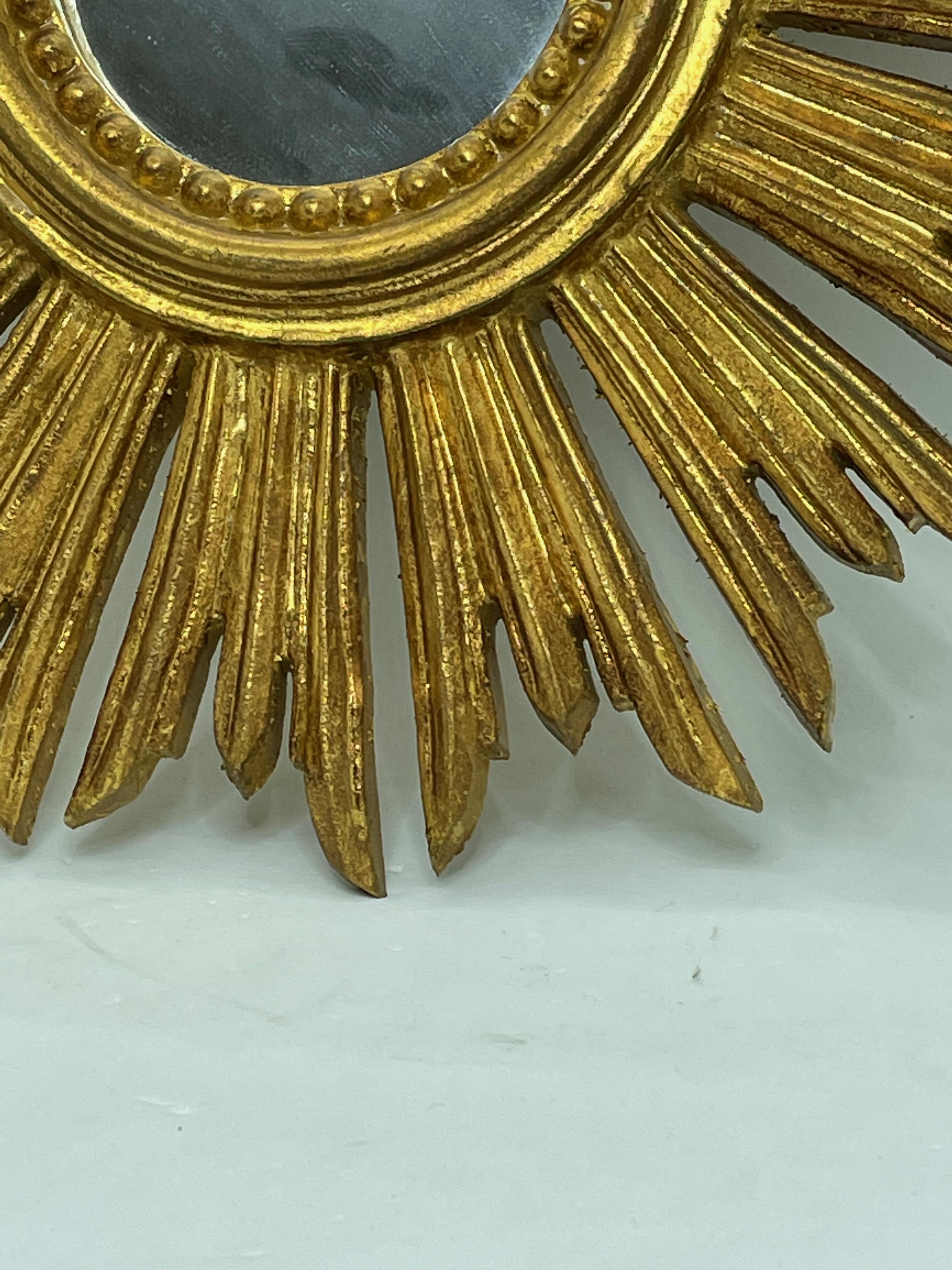 A gorgeous petite starburst mirror. Made of gilded wood. No chips, no cracks, no repairs. It measures approximate: 12 1/2