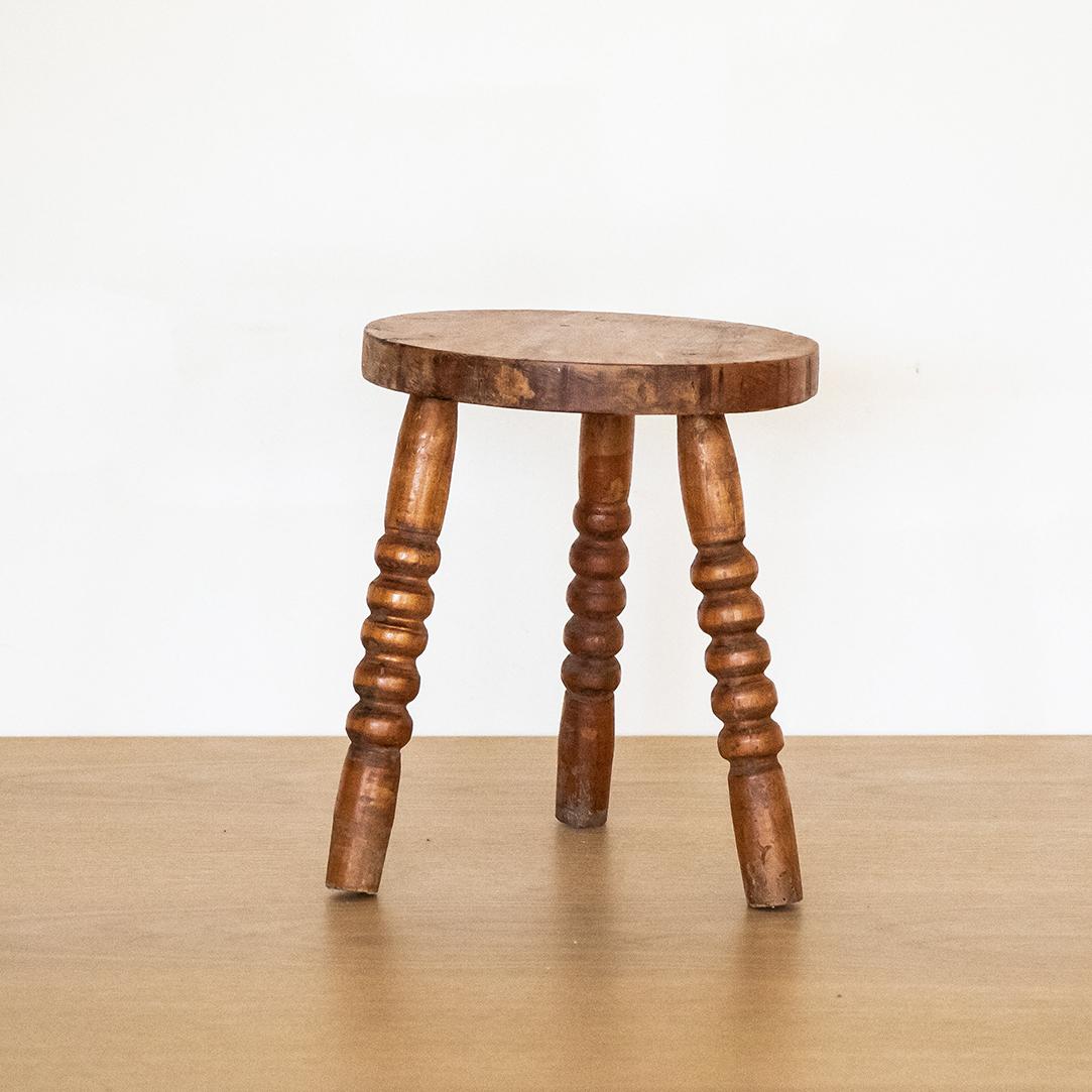 Petite vintage wood stool with knobby legs and circular seat from France. Original wood finish with great age markings and patina. Great as small side table or on a counter top for display.