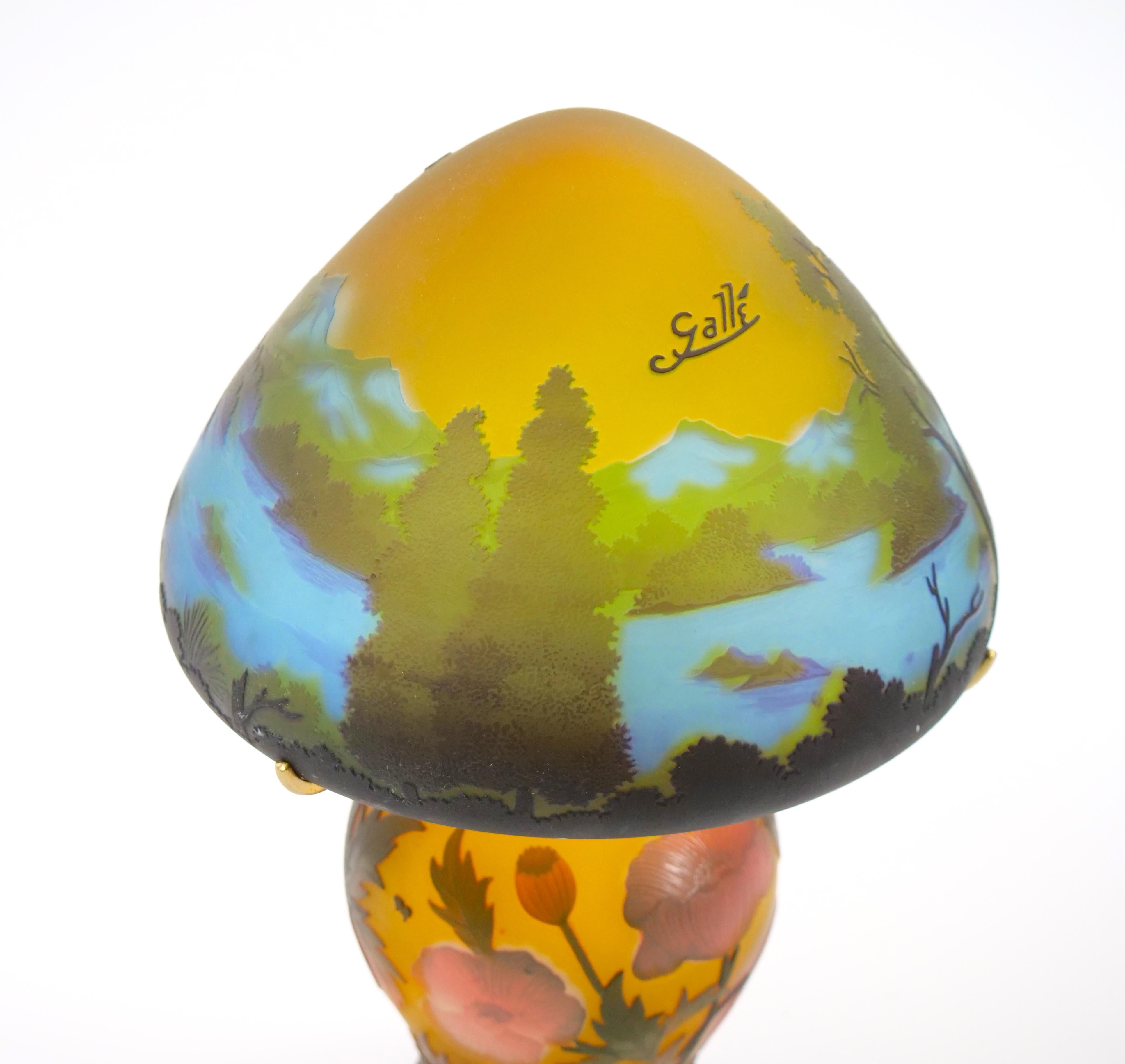 Magnifique lampe de table en verre camée de Galle avec abat-jour représentant une forêt au bord d'un lac avec des montagnes au loin, et standard présentant de jolies fleurs roses et orange dans différents états d'épanouissement sur un fond chaud de