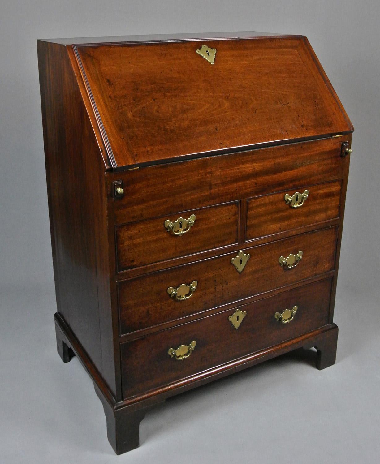 A very small and most attractive George II mahogany bureau retaining original handles and escutcheons. Oak lined drawers with fine dovetailed joints. In very good original condition and of a charming size and yet very usable and practical. Interior