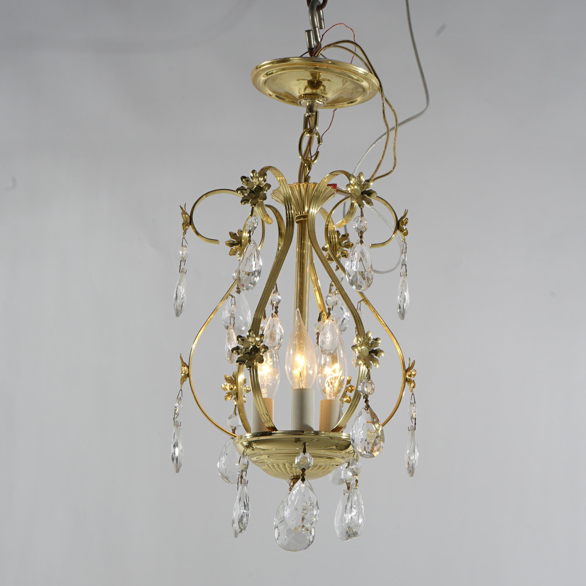 A petite chandelier offers gilt cast metal frame with three candle lights, hanging crystals, scroll and floral elements, 20thC

Measures - 20