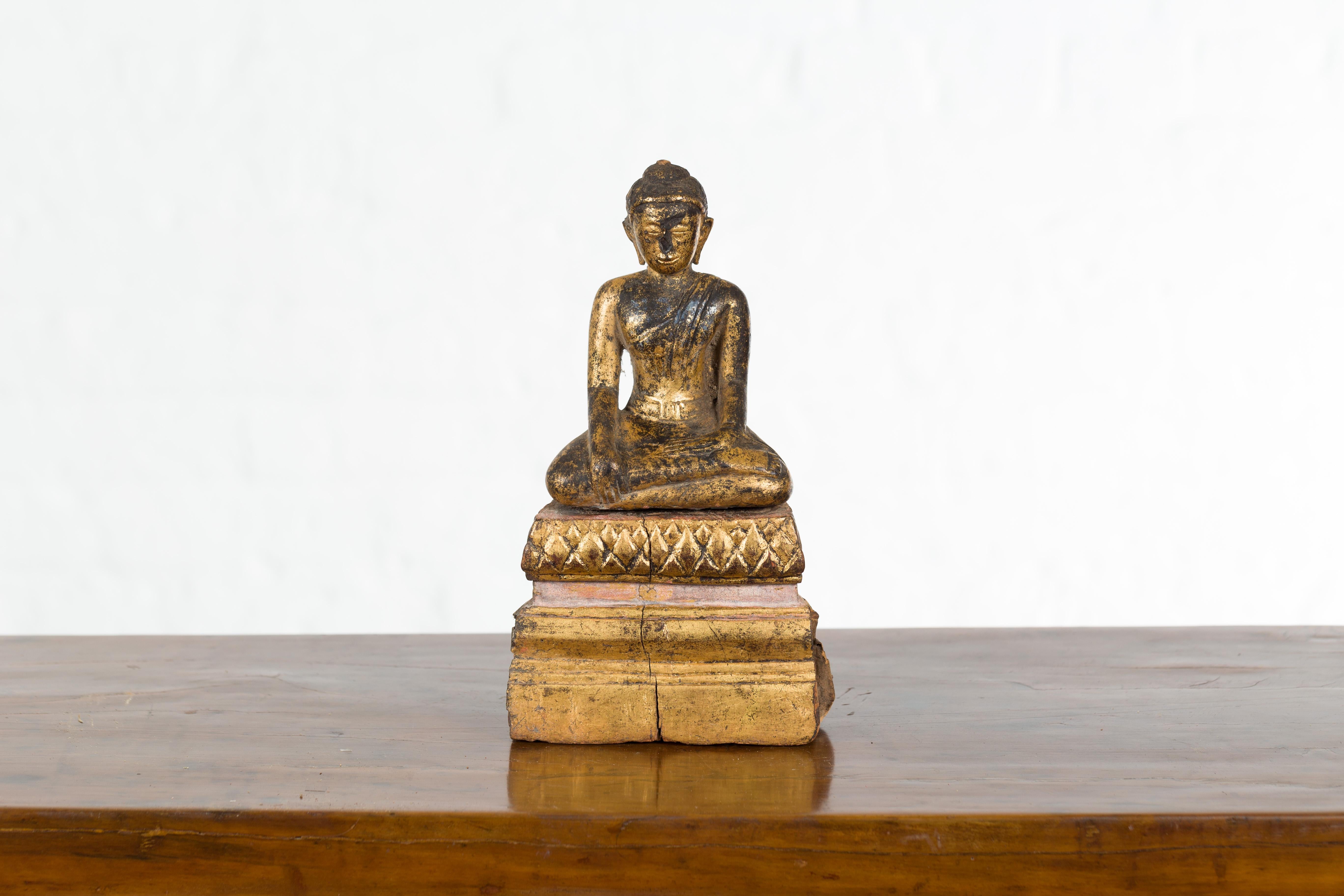 A petite antique Thai giltwood Buddha sculpture from the Ayutthaya period, with the Bhumisparsha Mudra, Calling the Earth to Witness. Created in Thailand during the Ayutthaya period (1350–1767), this small giltwood sculpture depicts the Buddha