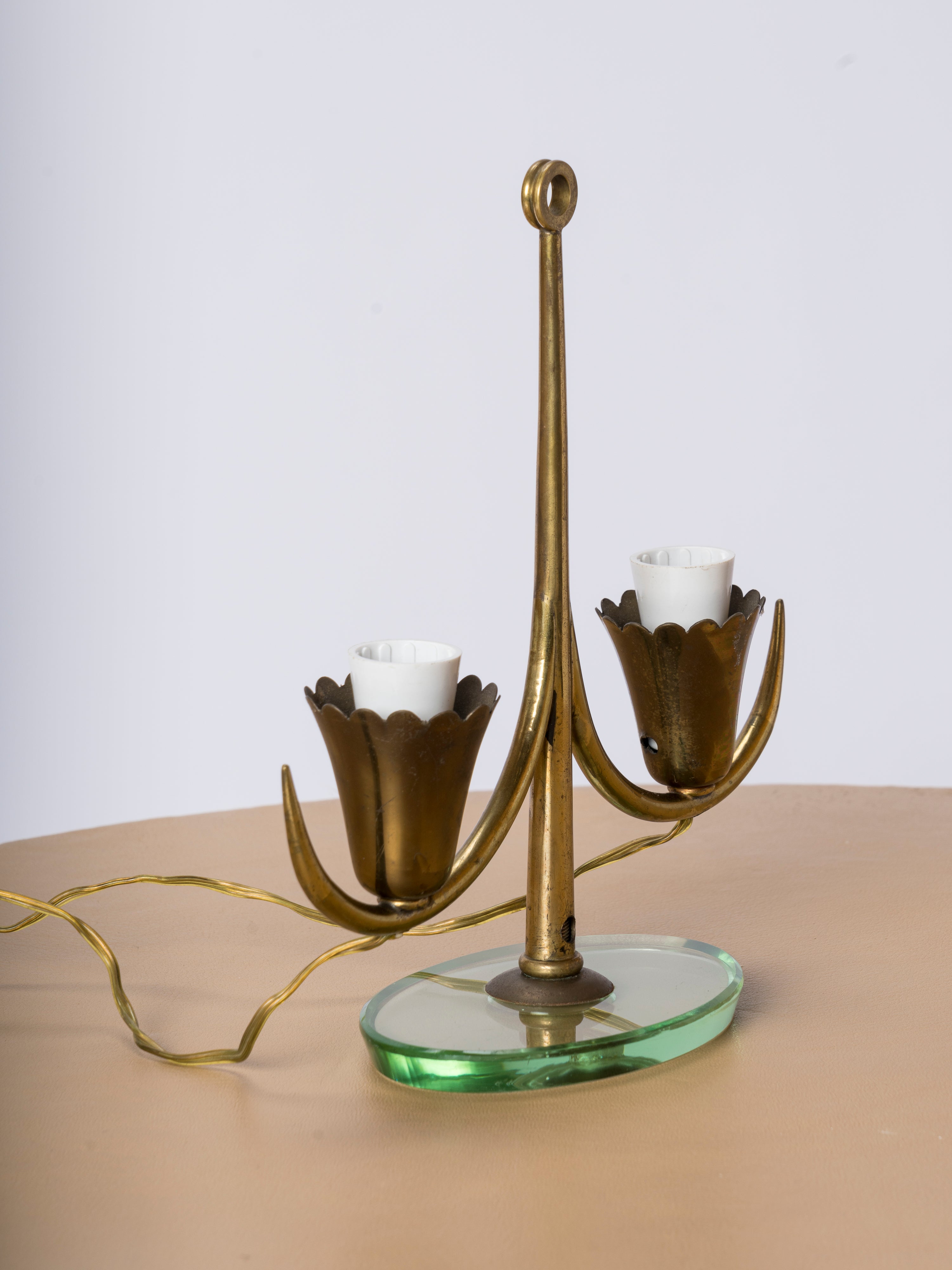Elegant table lamp attributed to Fontana Arte. Typical of Italian lighting productions from the 50's. Features a light green tinted glass base and a brass pole with two sockets. In the style of Pietro Chiesa. European socket and wiring.