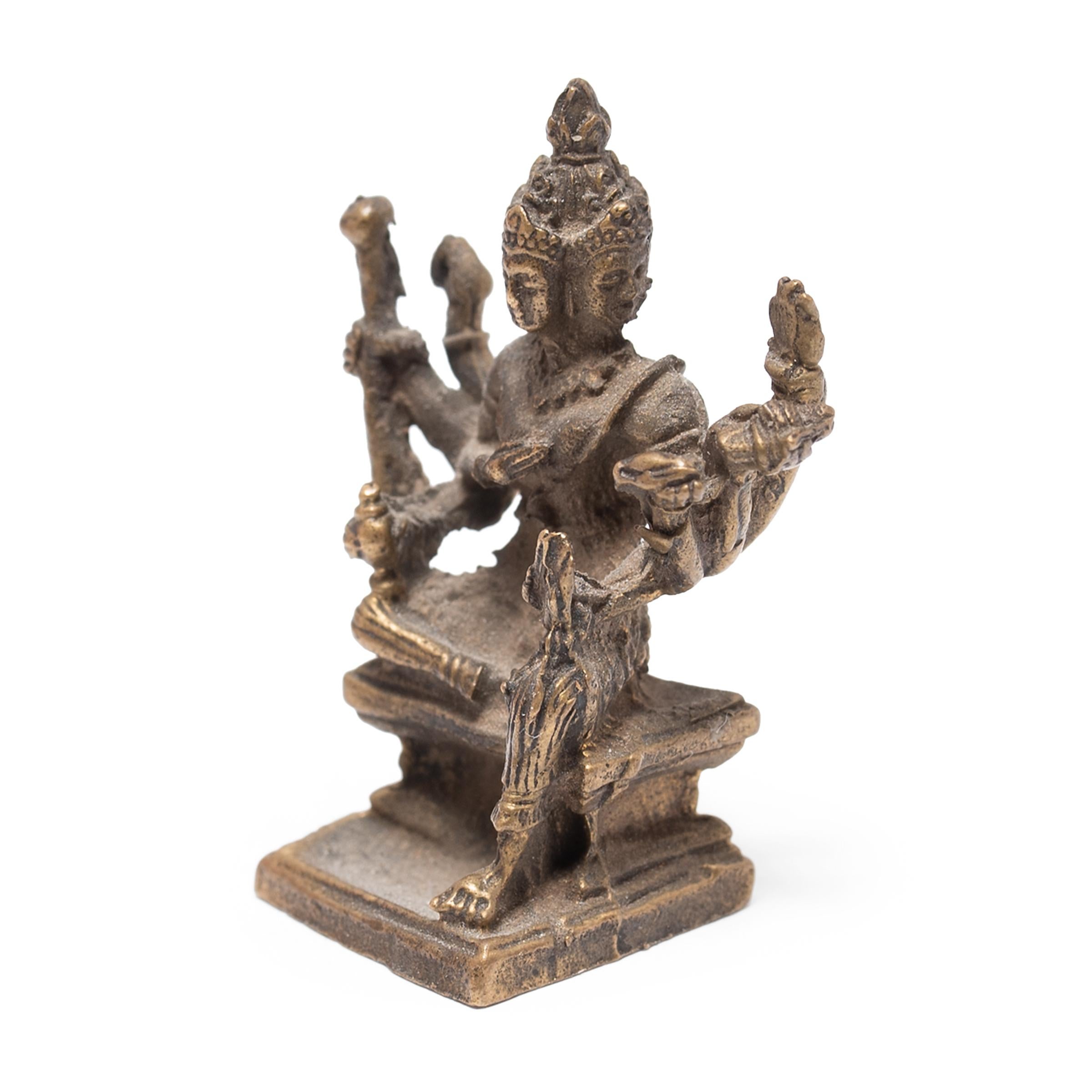 Cette petite sculpture en laiton représente la déesse à huit bras Mahapratisara, vénérée dans le bouddhisme tibétain comme un bodhisattva protecteur et garant de la prospérité. Elle est considérée comme une émanation du Bouddha Ratnasambhava, l'un