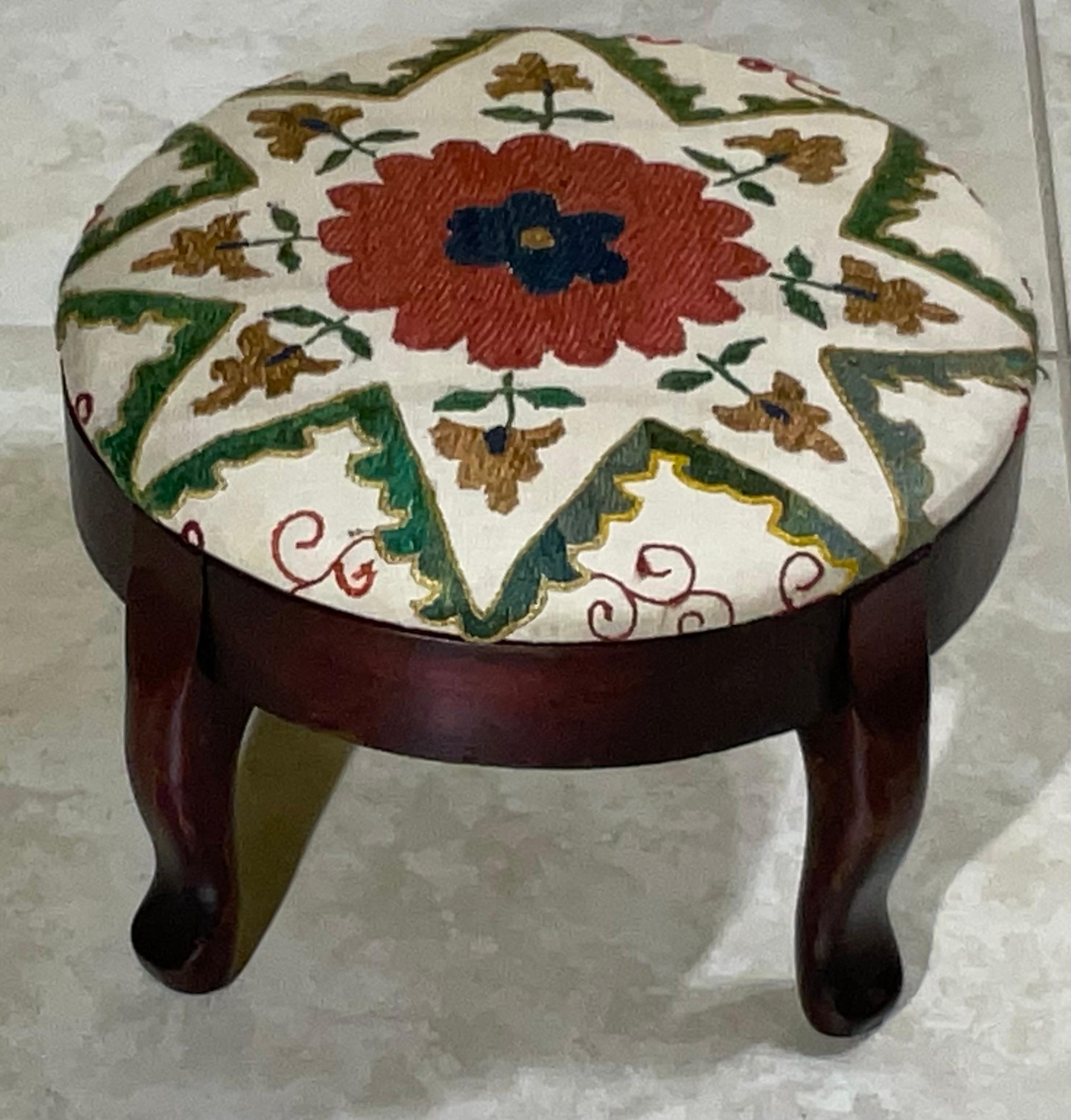 Este precioso y exclusivo reposapiés es una auténtica pieza única, perfecta para añadir un toque de elegancia bohemia y estilo global a cualquier habitación. Presenta una elegante parte superior textil suzani hecha a mano, que exhibe intrincados