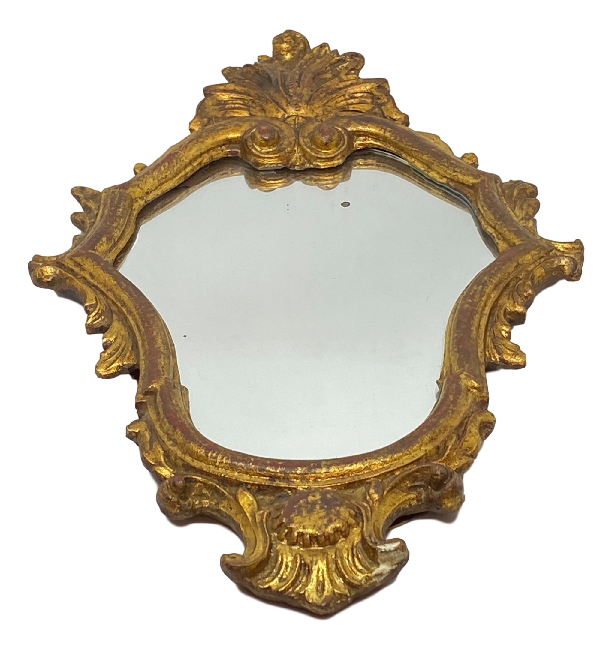 Stunning Hollywood Regency style toleware mirror. The gilt frame surrounds a glass mirror. Made in Italy, circa 1960s. Beautiful small mirror for any room. Mirror with some age and blind or distressed parts. Nice addition to any room.