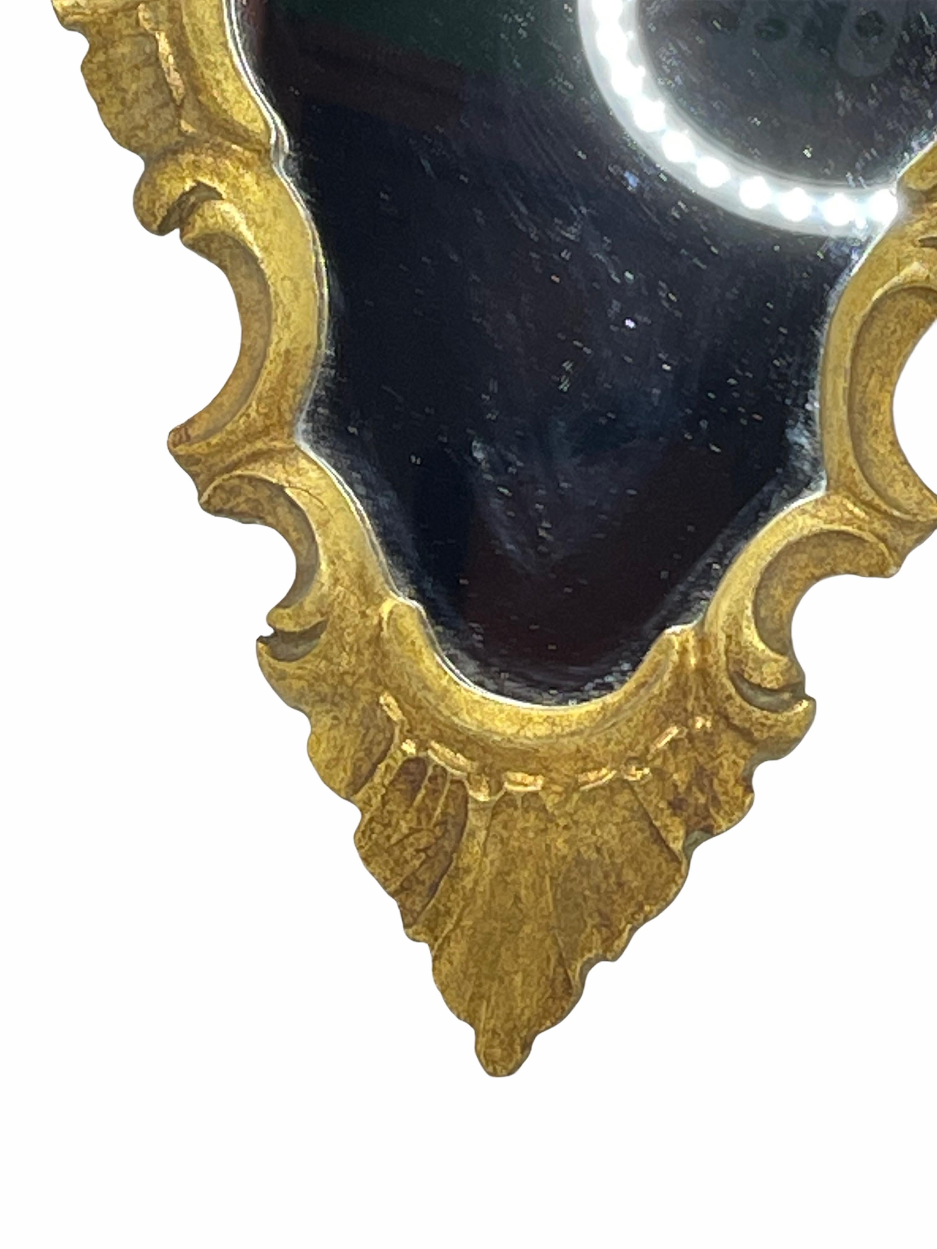 Stunning Hollywood Regency style toleware mirror. The gilt frame surrounds a glass mirror. Made in Italy, circa 1960s. Beautiful small mirror for any room. Nice addition to any room.