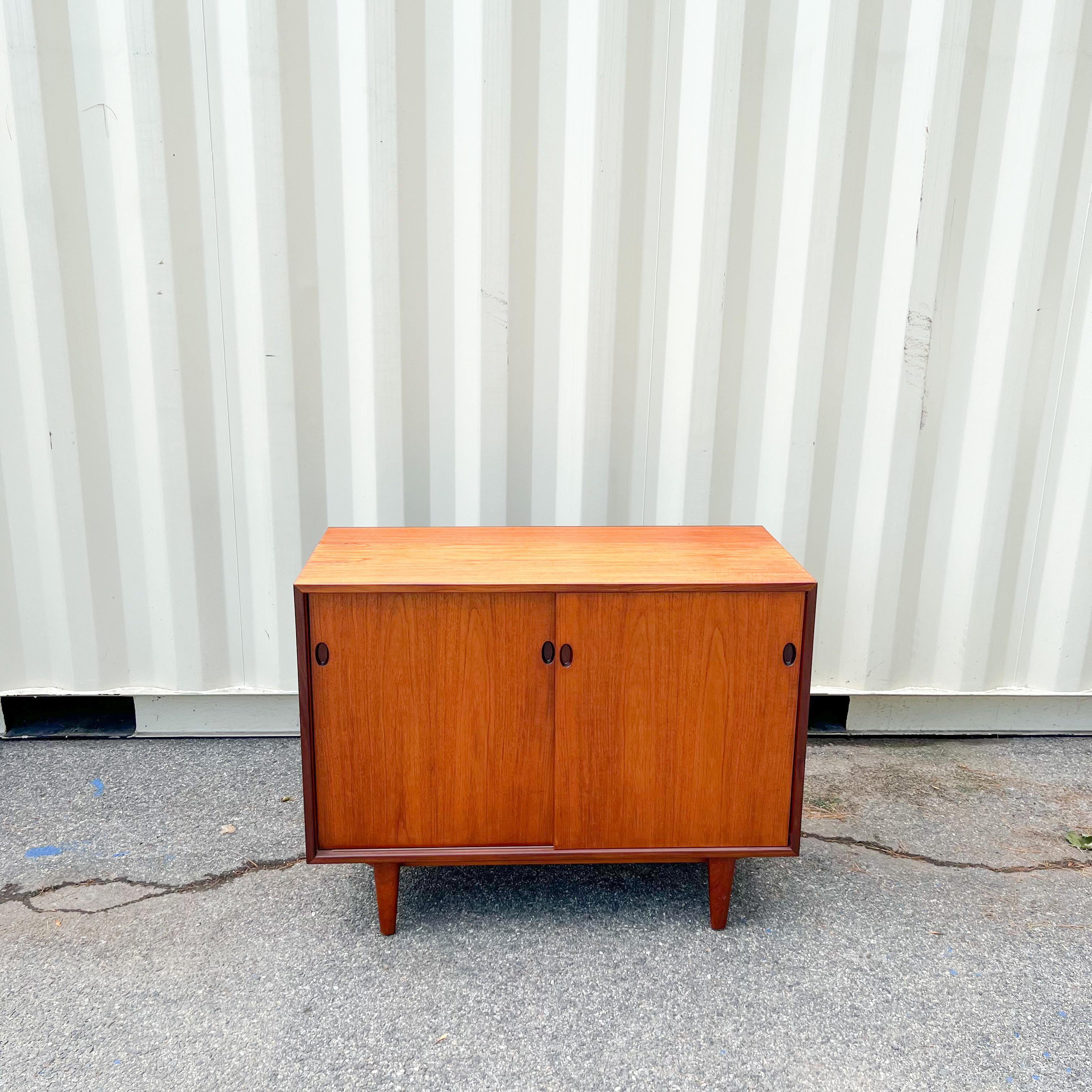 Mid-Century Modern danish teak petite credenza with sliding doors designed by IB Kofod-Larsen for Clausen and Son. Finished back.