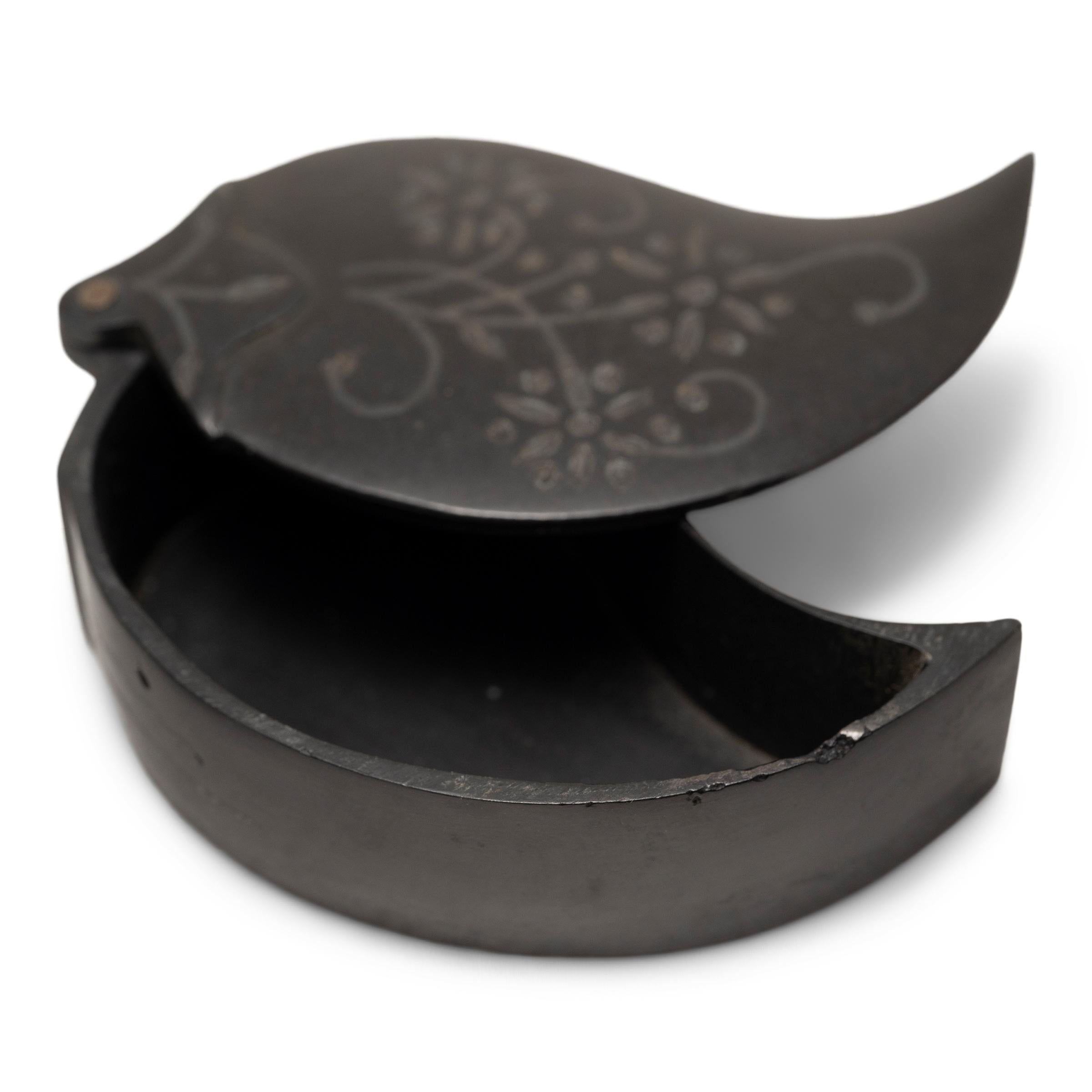 This petite keepsake box with a swivel lid is crafted in the tradition of Indian bidri-ware, with a dark metal body decorated with simple silver inlay. Composed of a zinc and copper alloy known as gun metal, the small box is cast in the form of a