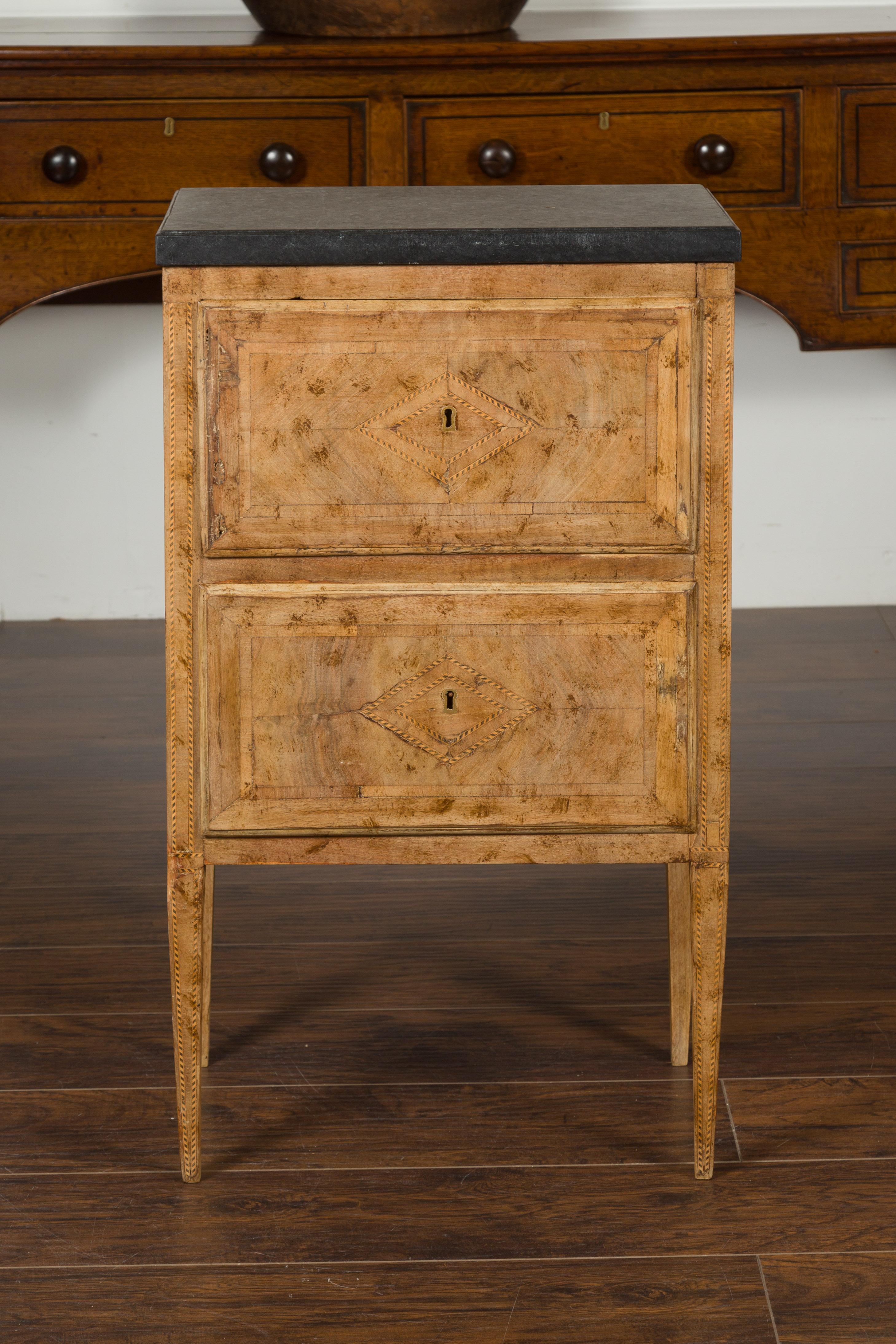 A petite Italian neoclassical period bleached burl wood two-drawer commode from the early 19th century, with dark grey / black marble top and striped banding. Created in Italy during the early years of the 19th century, this petite commode features