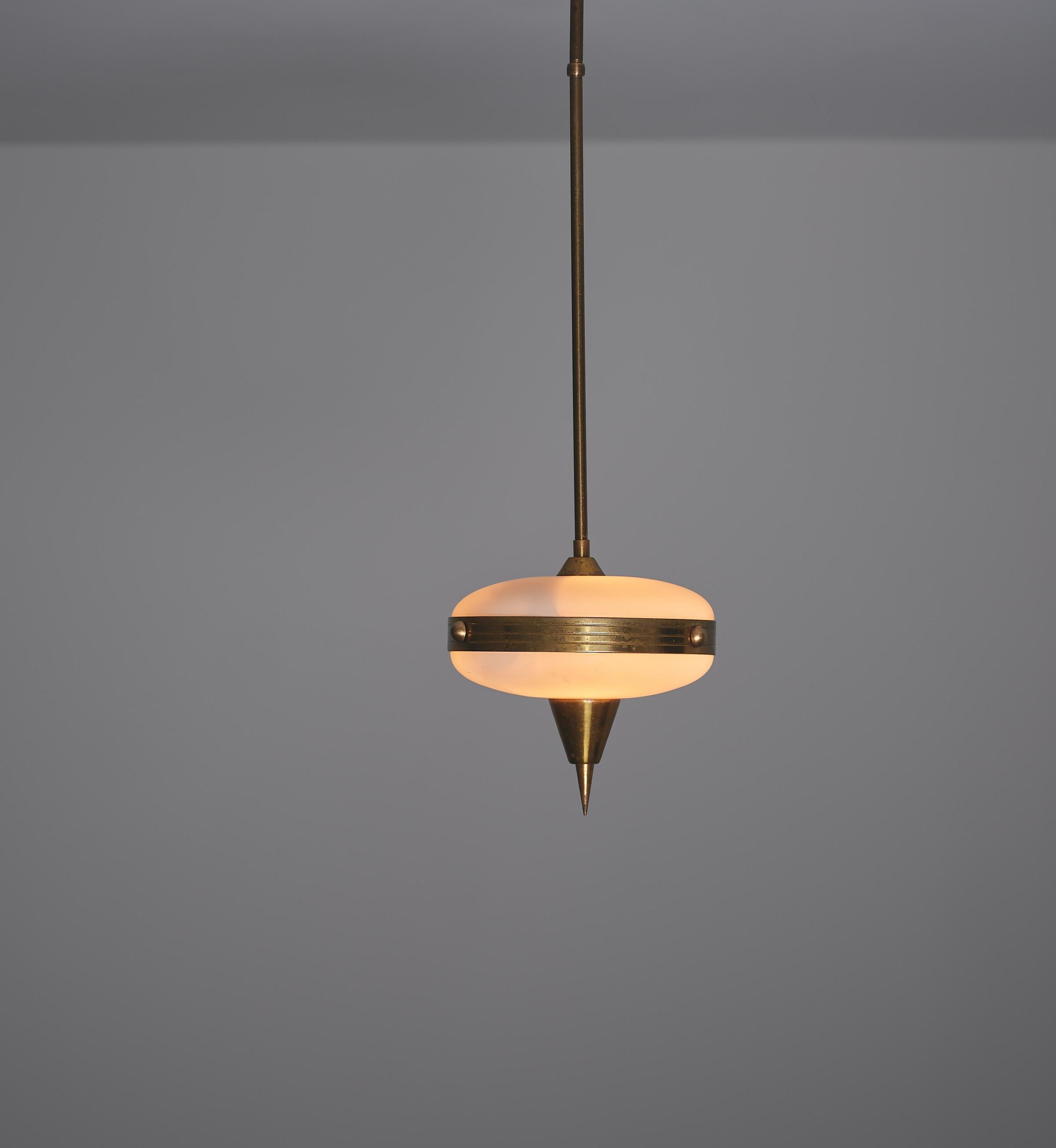 This elegant and stylish pendant lamp, produced in Italy in the 1950s, combines sleek modernist design with the warmth of vintage materials. Its petite form is crafted from brass, which features a lovely, natural patina developed over time, adding