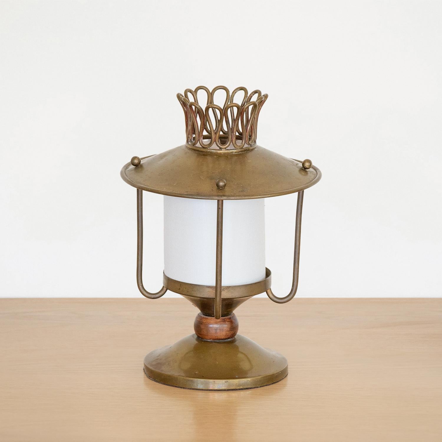 Beautiful petite brass table lamp from Italy, 1940's.  Unique brass lantern shape with brass squiggle detail on top. Circular base with wood ball on stem. Brass balls on top of lantern are removable in order to remove top and access bulb. Newly