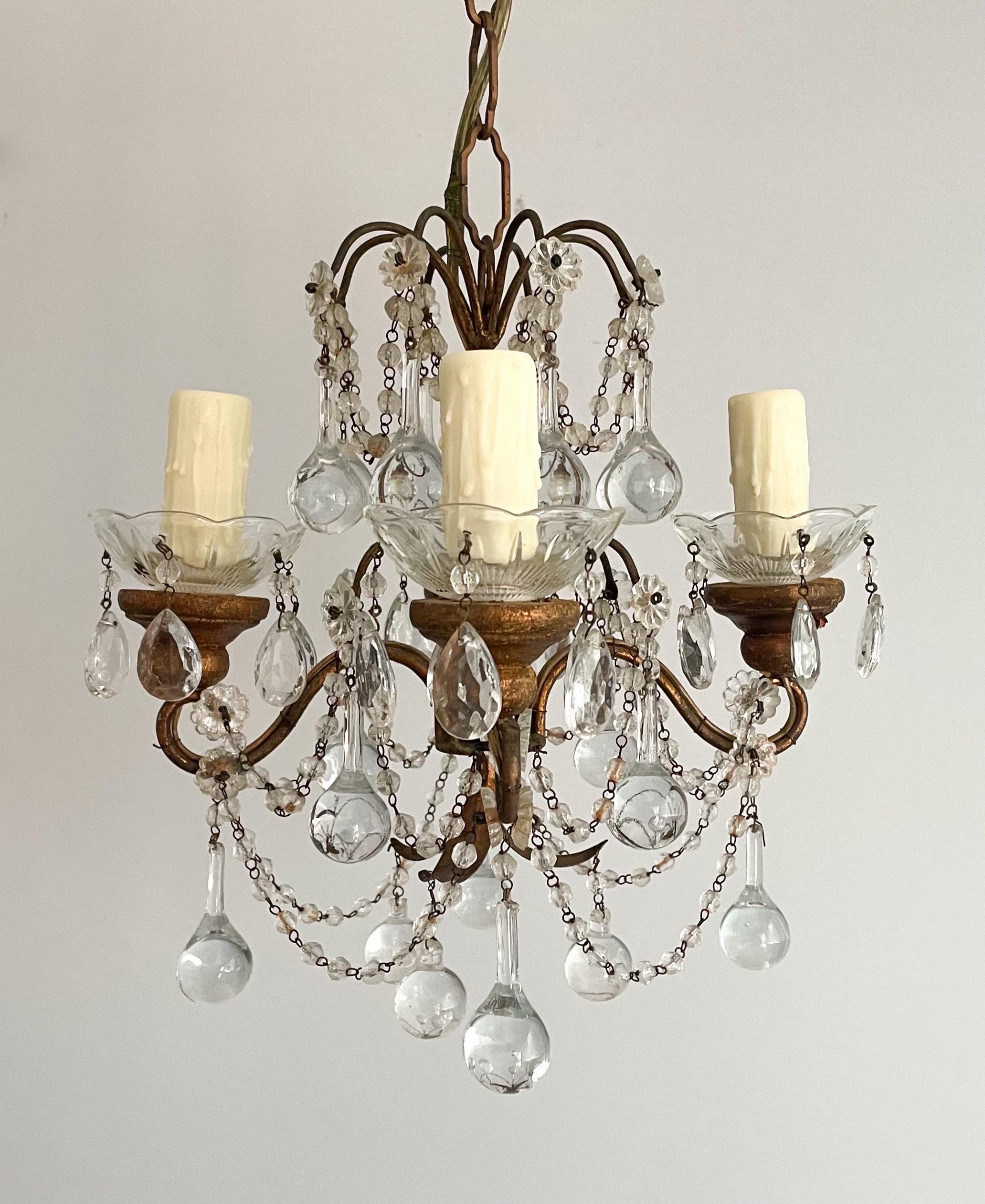 Gorgeous, petite 1940s Italian gilt-iron and crystal beaded chandelier. 

 This small but impactful chandelier consists of a scrolled gilt-iron frame with gilt wood accents, Murano glass drops and bead swags. The chandelier is in working