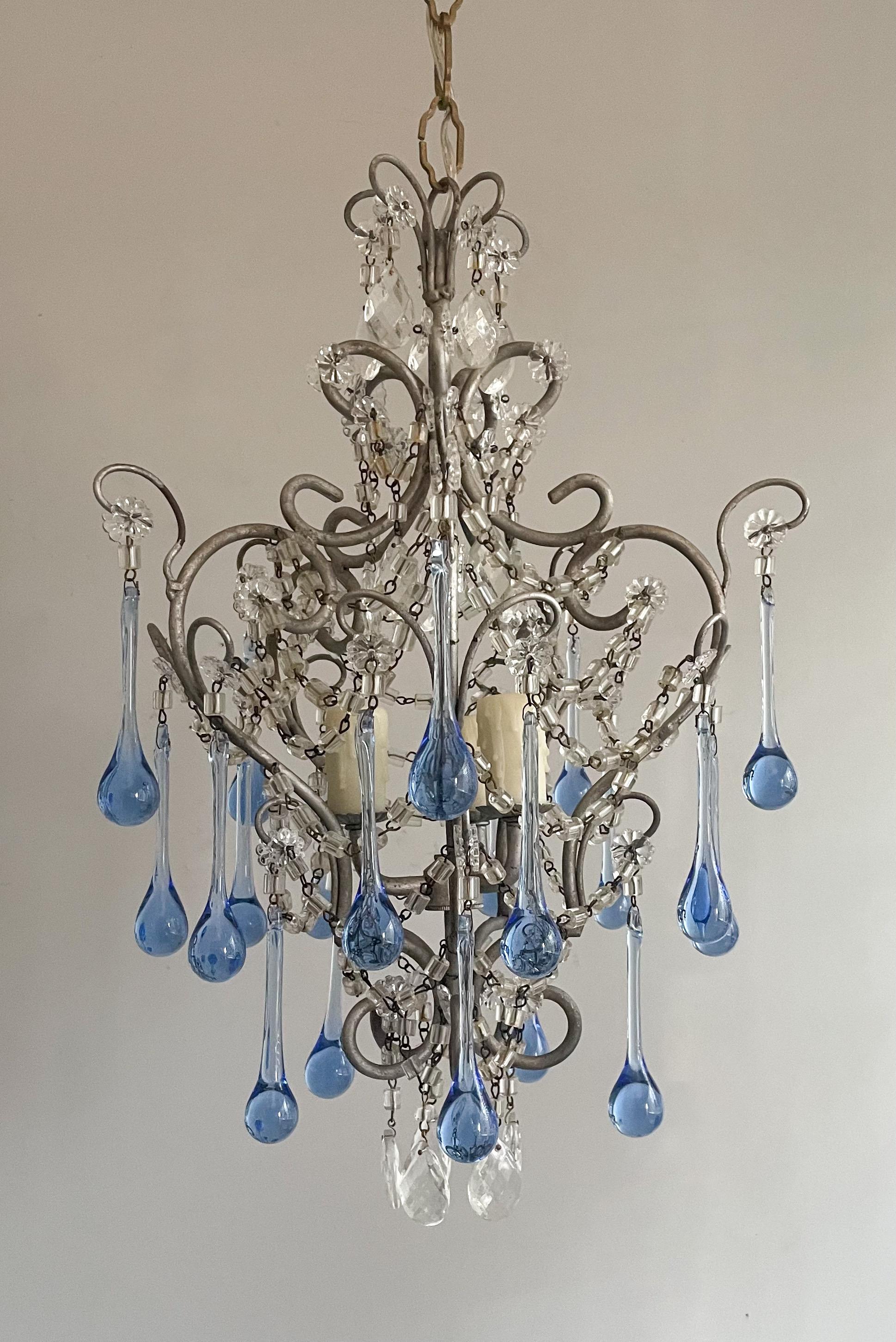 Beautiful, Italian 1960s petite iron and crystal chandelier in the provincial style.

The chandelier features a delicately scrolled iron frame in a sliver-leafed finish. Light sapphire blue Murano glass drops and macaroni beads adorn the fixture