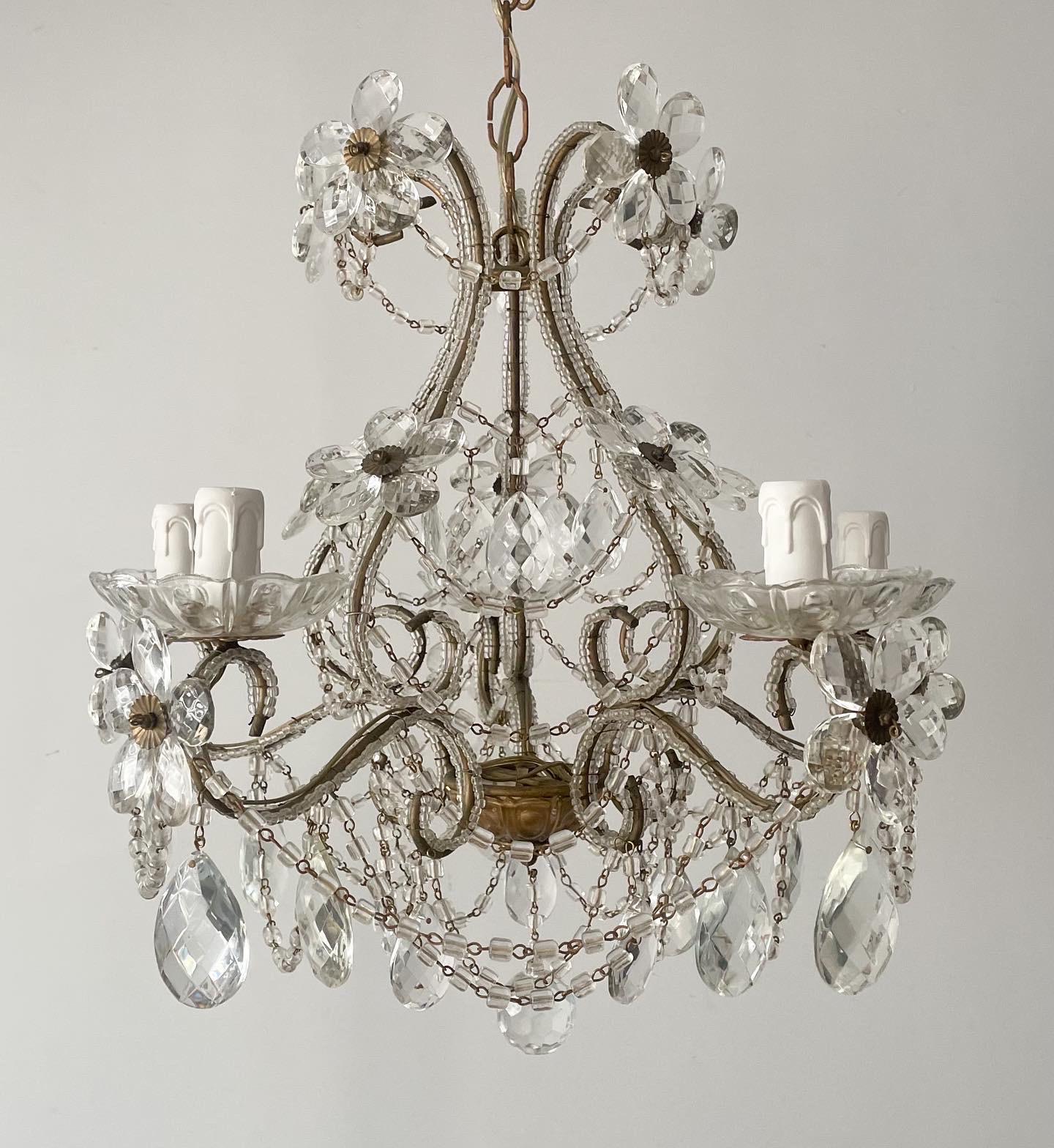 Gorgeous, Italian 1940s petite-scale gilt-iron and crystal beaded chandelier with glass flowers.

The chandelier consists of a scrolled iron frame outline with glass beads, decorated with flowers made of crystal prisms and macaroni glass swags.