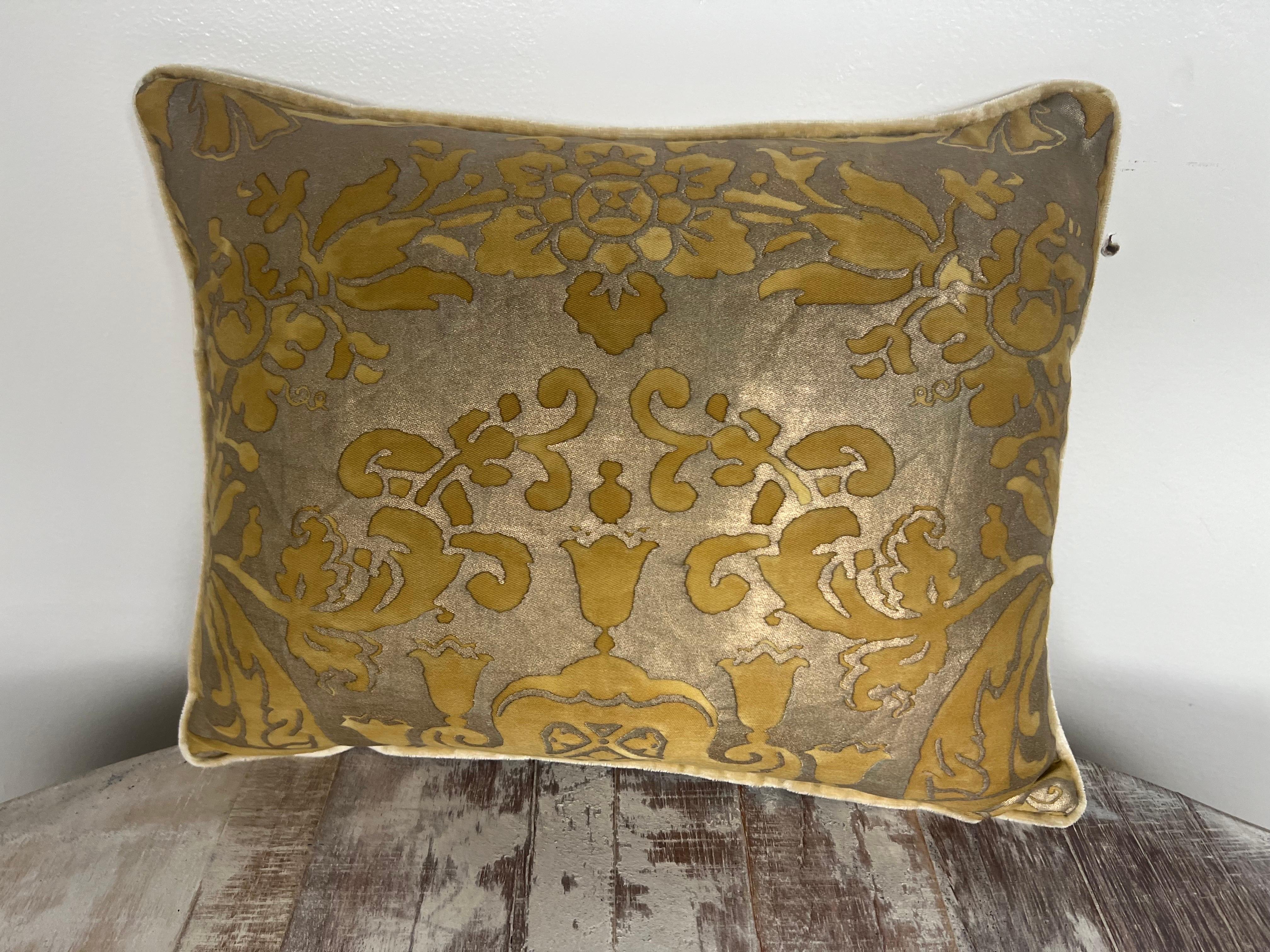 Questo cuscino decorativo di piccole dimensioni presenta un autentico tessuto Fortuny in una ricca tavolozza di colori ocra e tortora, che mostra un classico motivo damascato con intricati elementi floreali e fogliati.  Il cuscino è rifinito con un