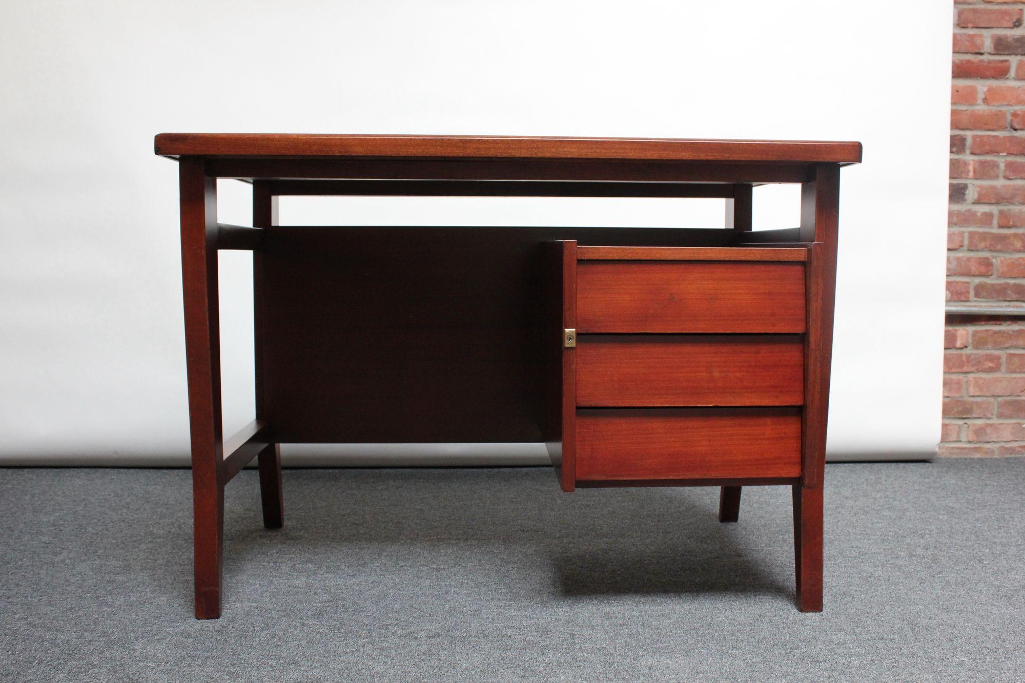 Diminutive Italian student desk in stained mahogany designed by Gio Ponti for Schirolli, ca. 1950s, Italy. Sculptural form with angular leg details, presenting a sharp profile.
There are three drawers and an additional open storage section created