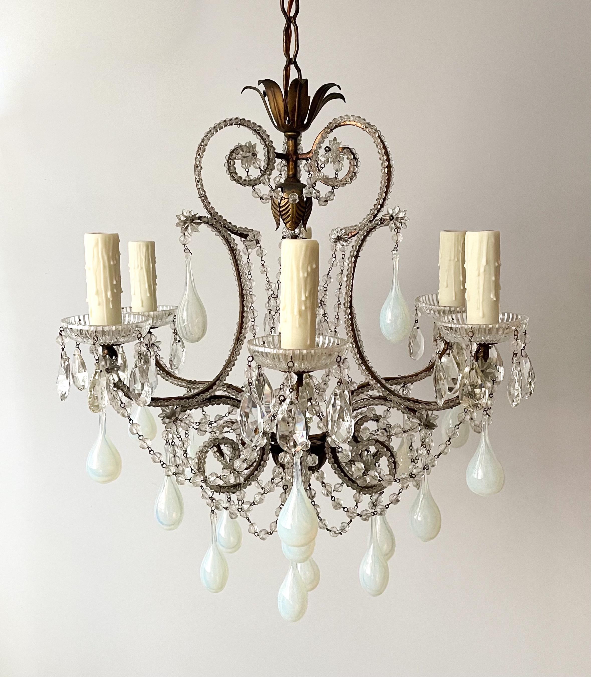 Beautiful, petite-scale, Italian 1940s gilt-iron and crystal chandelier with opaline glass drops.

The chandelier consists of scrolled gilt-iron framed outlined with small glass beads and decorated with rare hollow opaline glass drops.

The