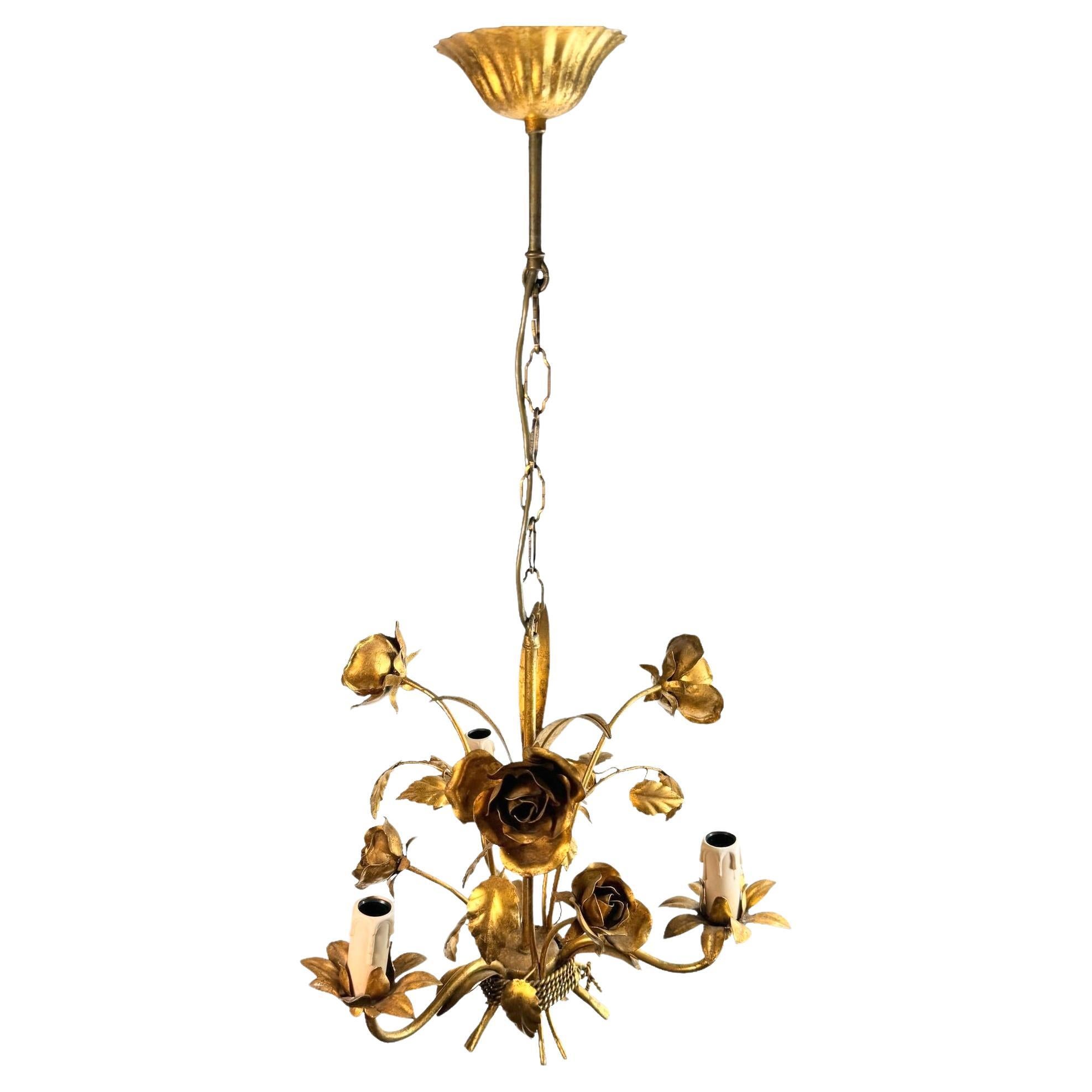 A Hollywood Regency midcentury gilt tole roses chandelier, the fixture requires three European E14 candelabra bulbs, each bulb up to 40 watts. This light has a beautiful patina and gives each room an eclectic statement. Found at an Estate Sale in