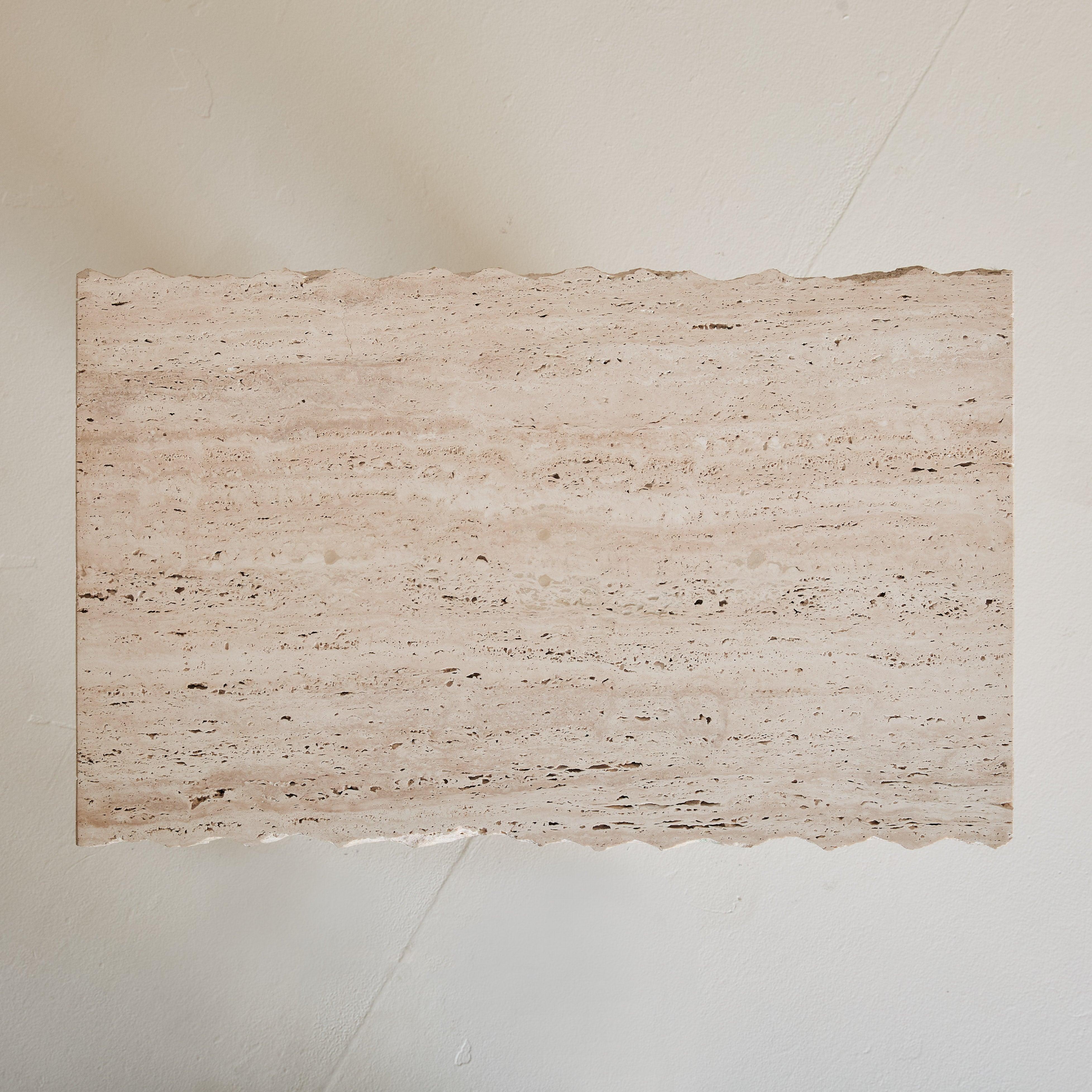 A petite 1970s Italian console table crafted entirely from warm, earthy-toned unfilled travertine. Its rough-hewn top showcases the raw beauty of the natural stone, complementing the clean, geometric lines of its dual-column base. Small in scale yet
