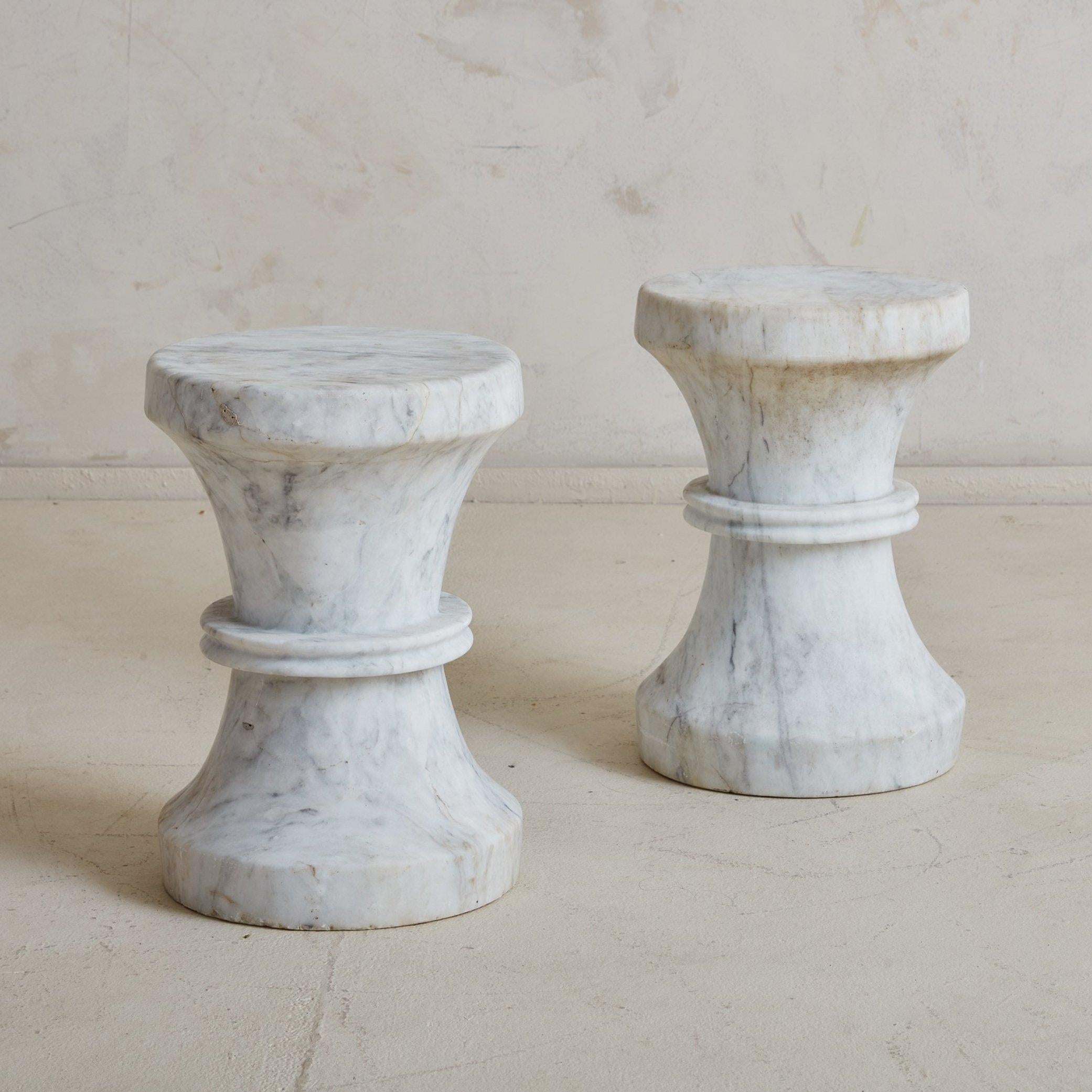 A 20th Century petite stool entirely crafted from solid white Italian Carrara marble. This Modern stool resembles a chess piece, displaying soft curves, ring details, and a round, flat base. The creamy white Carrara marble has stunning veining in