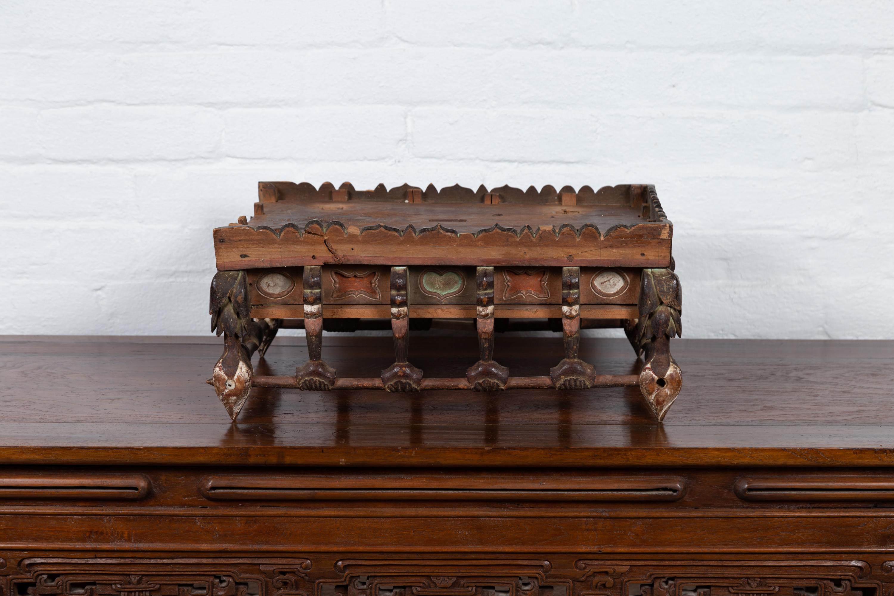 A petite Japanese Edo period Folk Art altar table from the 19th century, with carved and polychrome motifs. Born in Japan during the Edo period, this charming petite altar table presents a rectangular top, adorned with a three-quarter carved wood