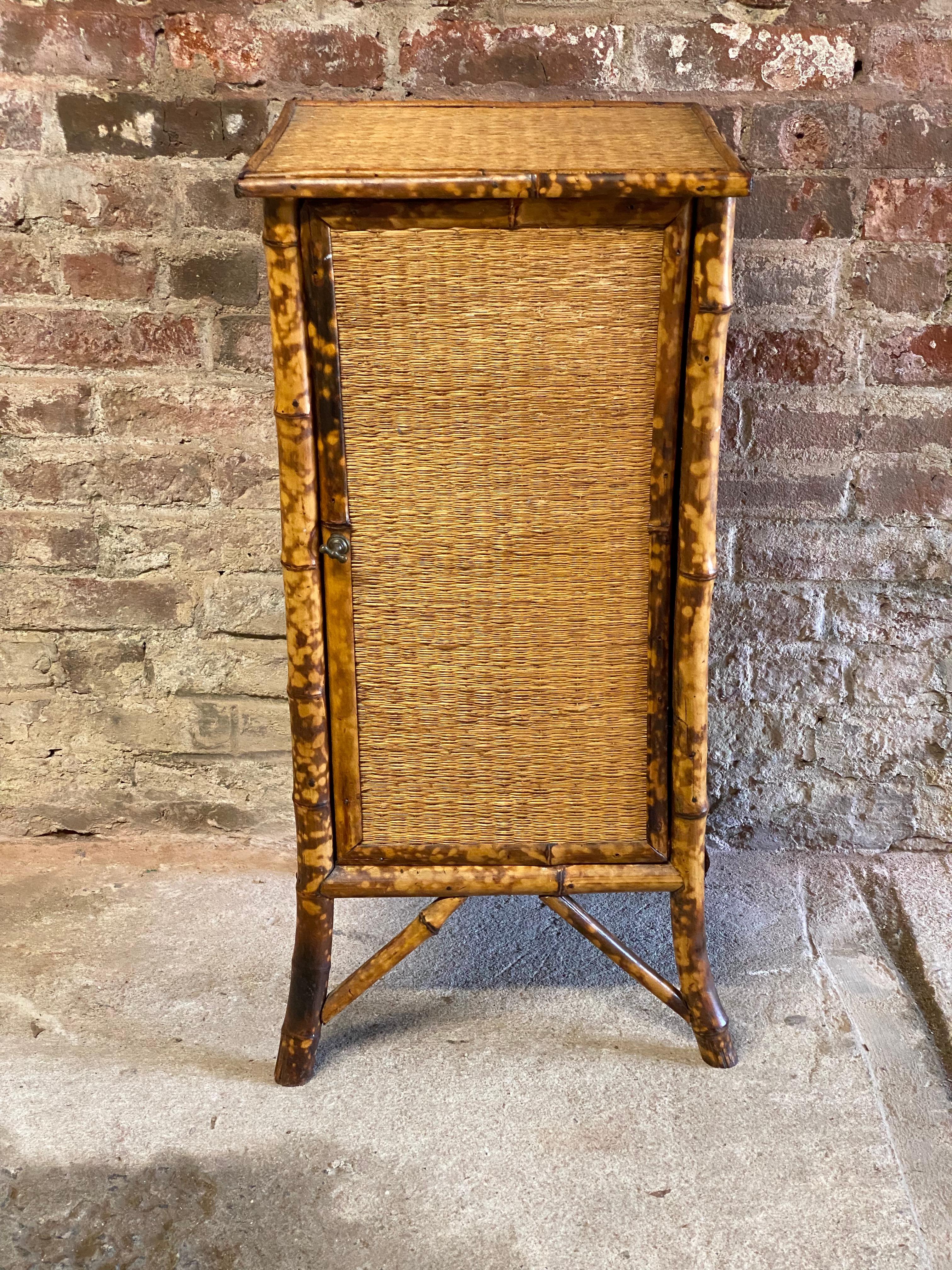 Petite Late Victorian grasscloth and bamboo cabinet. Just an amazing accent piece that can go anywhere in the home or office. Single fixed shelf. Good overall condition. Structurally sound and sturdy, yet extremely delicate. Wear commensurate with