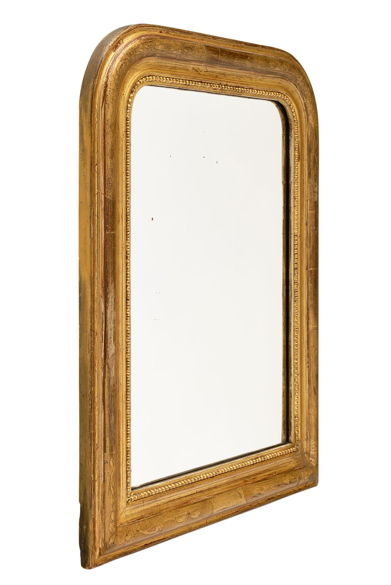 Petite Louis Philippe mirror from France with a wood and gesso frame; hand chiseled with a beautiful gold leaf. The sienna colored glaze shows through giving it a beautiful character and presence in any space.