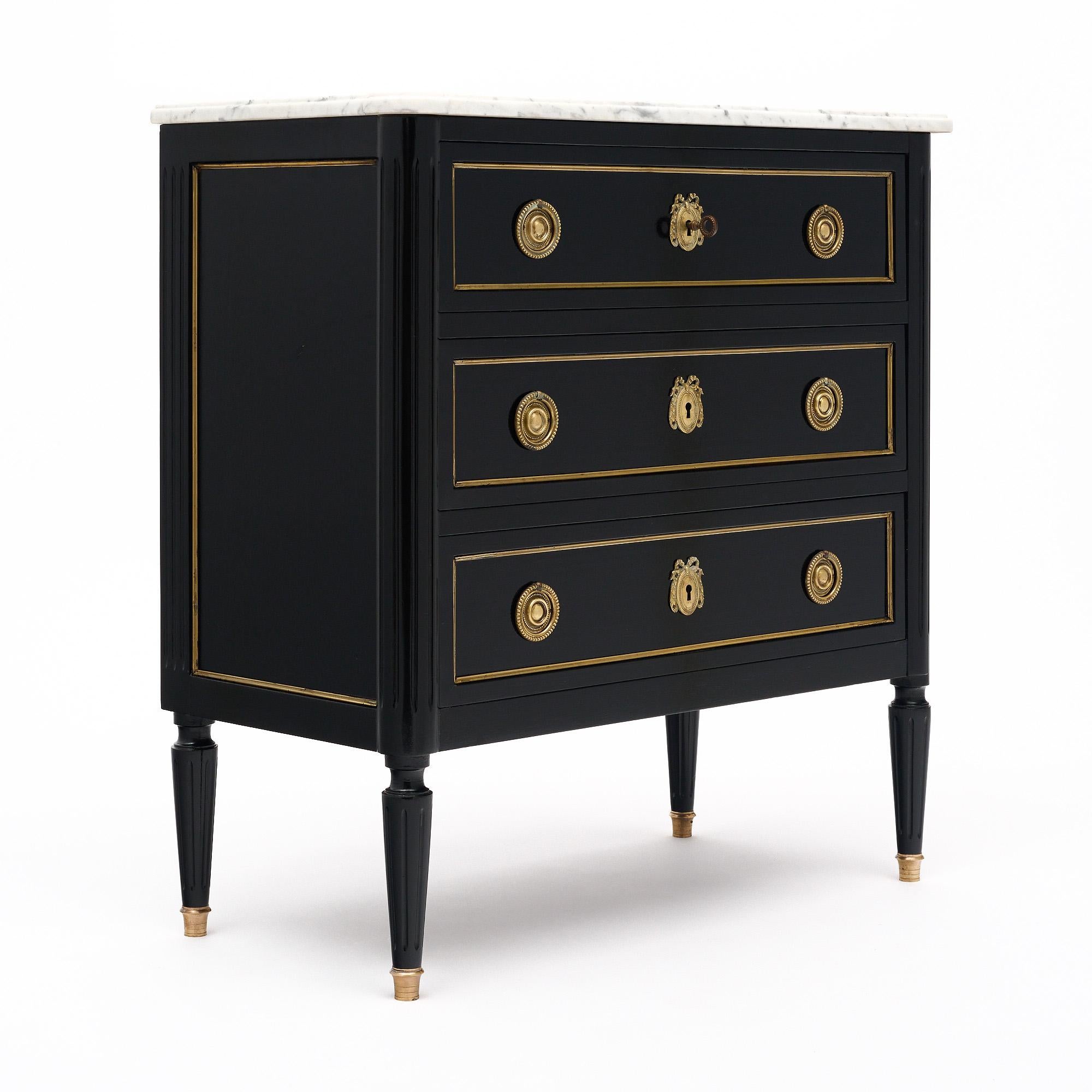 Chest of drawers in the Louis XVI style from France made of mahogany with an ebonized French polish finish of museum-quality. The case piece has Three dovetailed drawers all trimmed with brass and featuring cast brass hardware and pulls. There is