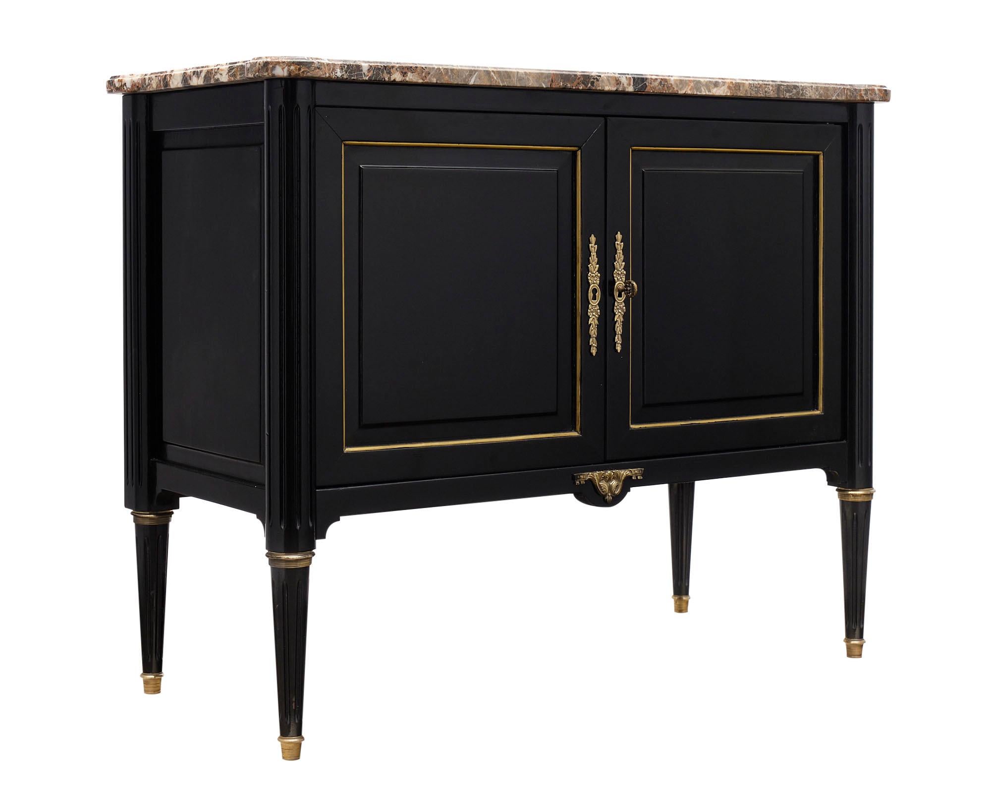 Petite Louis XVI style French buffet made of mahogany that has been ebonized and finished in a lustrous French polish. This elegant cabinet is topped with a “brêche” marble slab and enhanced with gilt trim and finely cast bronze hardware.