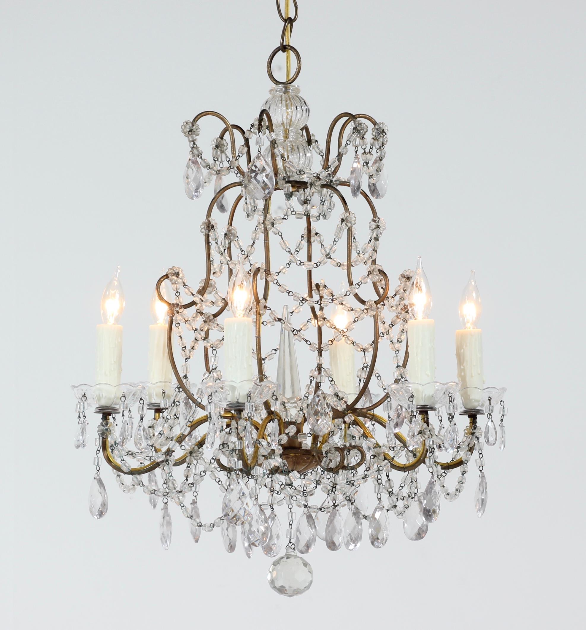 Very pretty, 1940s Italian gilt iron and crystal beaded chandelier. 

This petite-scale chandelier consists of a shapely gilded iron frame which is decorated with “macaroni” glass bead garlands and faceted prisms. Included are 6 vintage glass