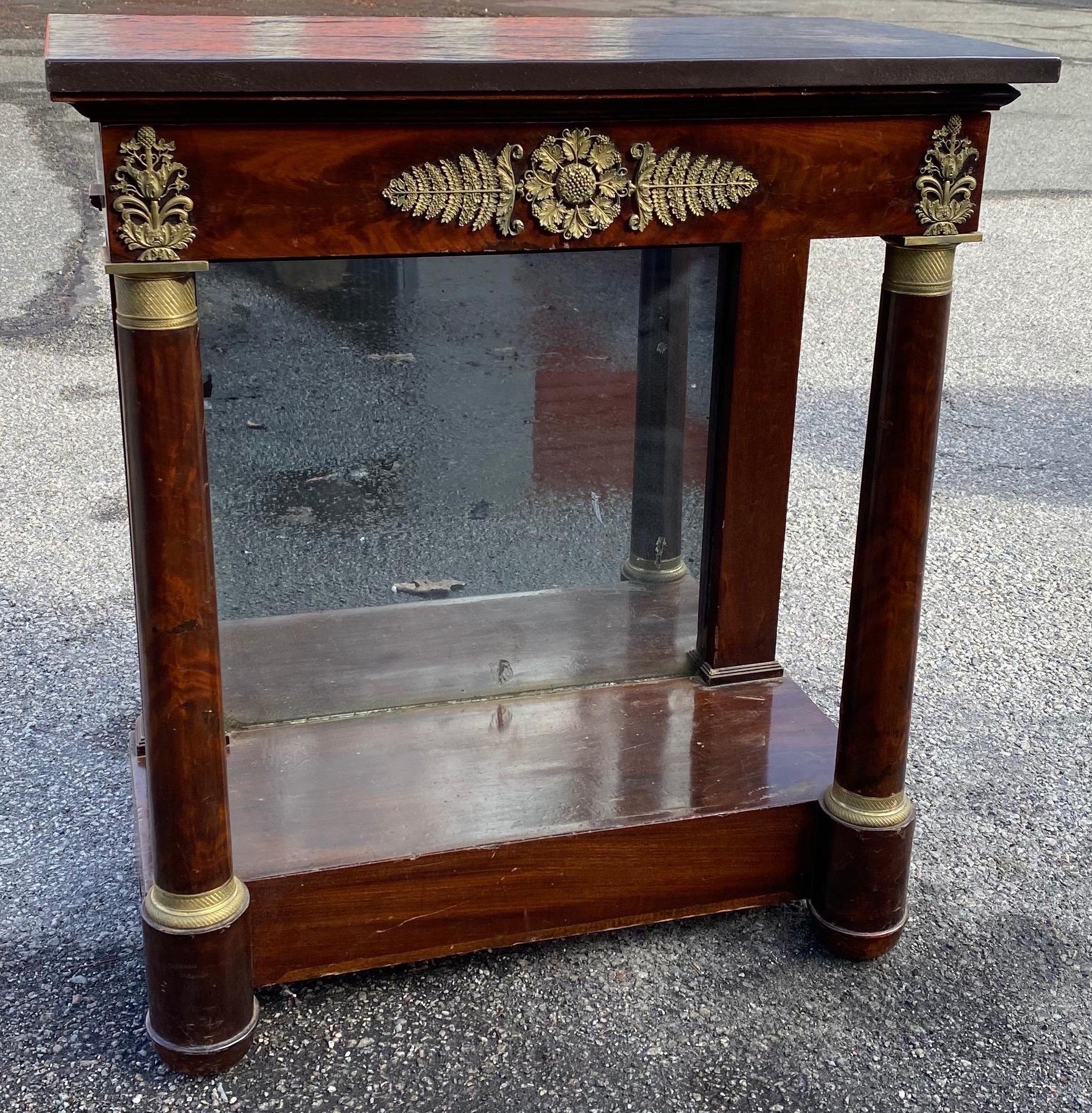 Petite mahogany French empire stone top console with great quality bronze mounts and original mirror. Single drawer.