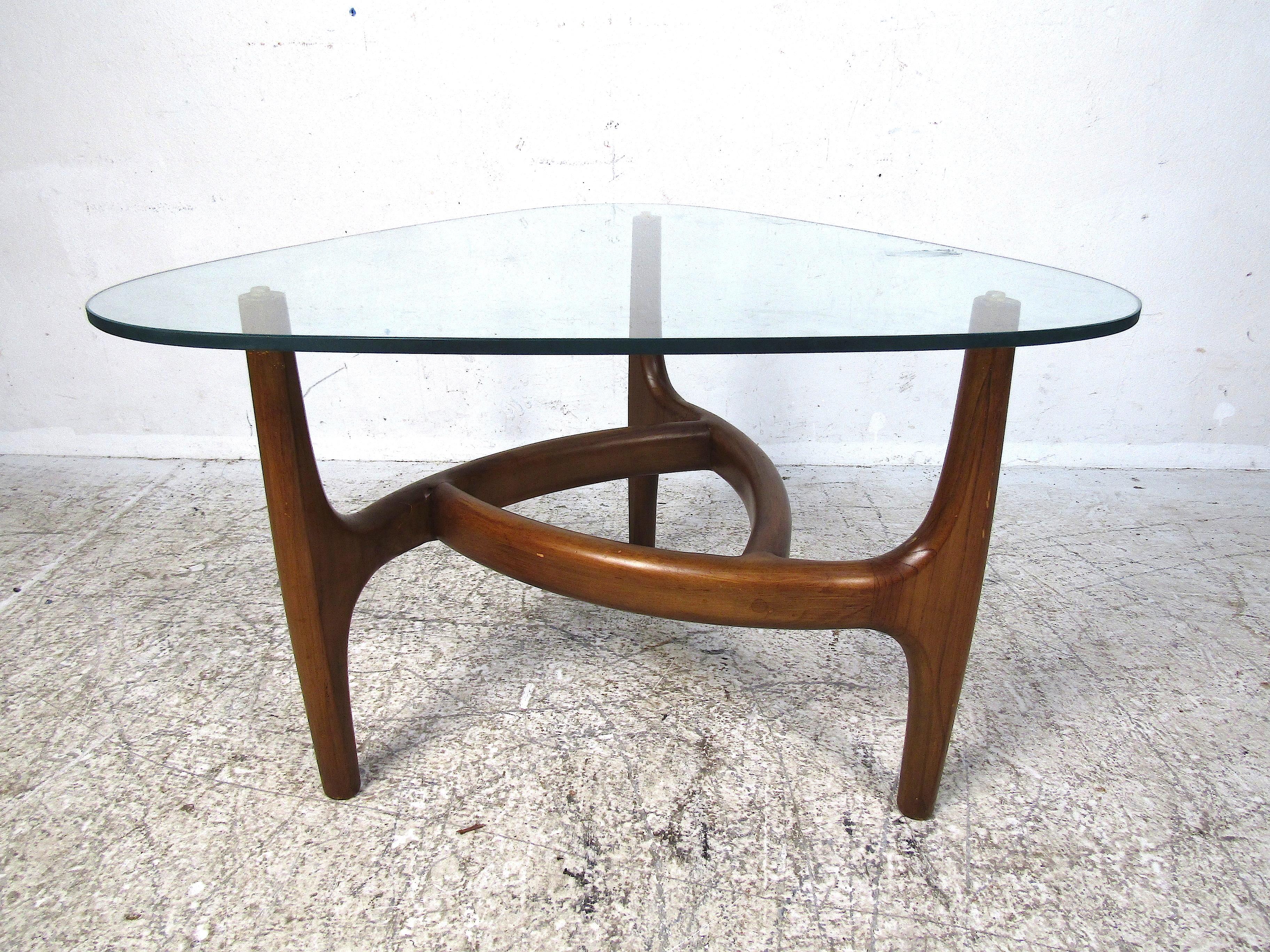 Stylish midcentury coffee table. Sculpted wooden frame with a triangular 3/8ths inch thick pane of glass with rounded edges serving as the tabletop. Designed by Adrian Pearsall for Craft Associates. Please confirm the item's location with the dealer