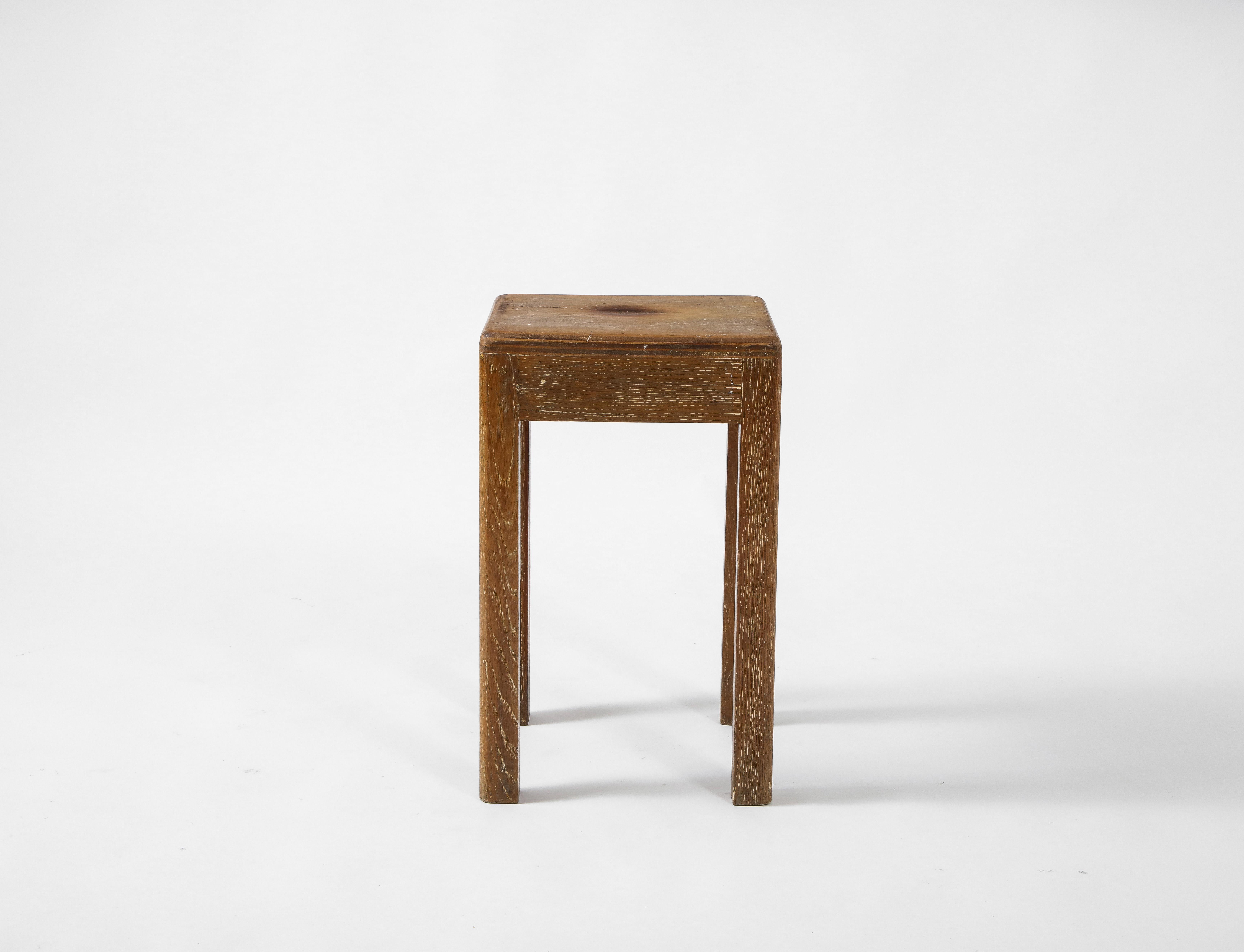 This petite midcentury French oak piece has an impeccably placed wooden knot in the center. It sits upon four thin legs that have earned a soft patina over time. Could function either as a stool or small side table. Notable discoloration at the