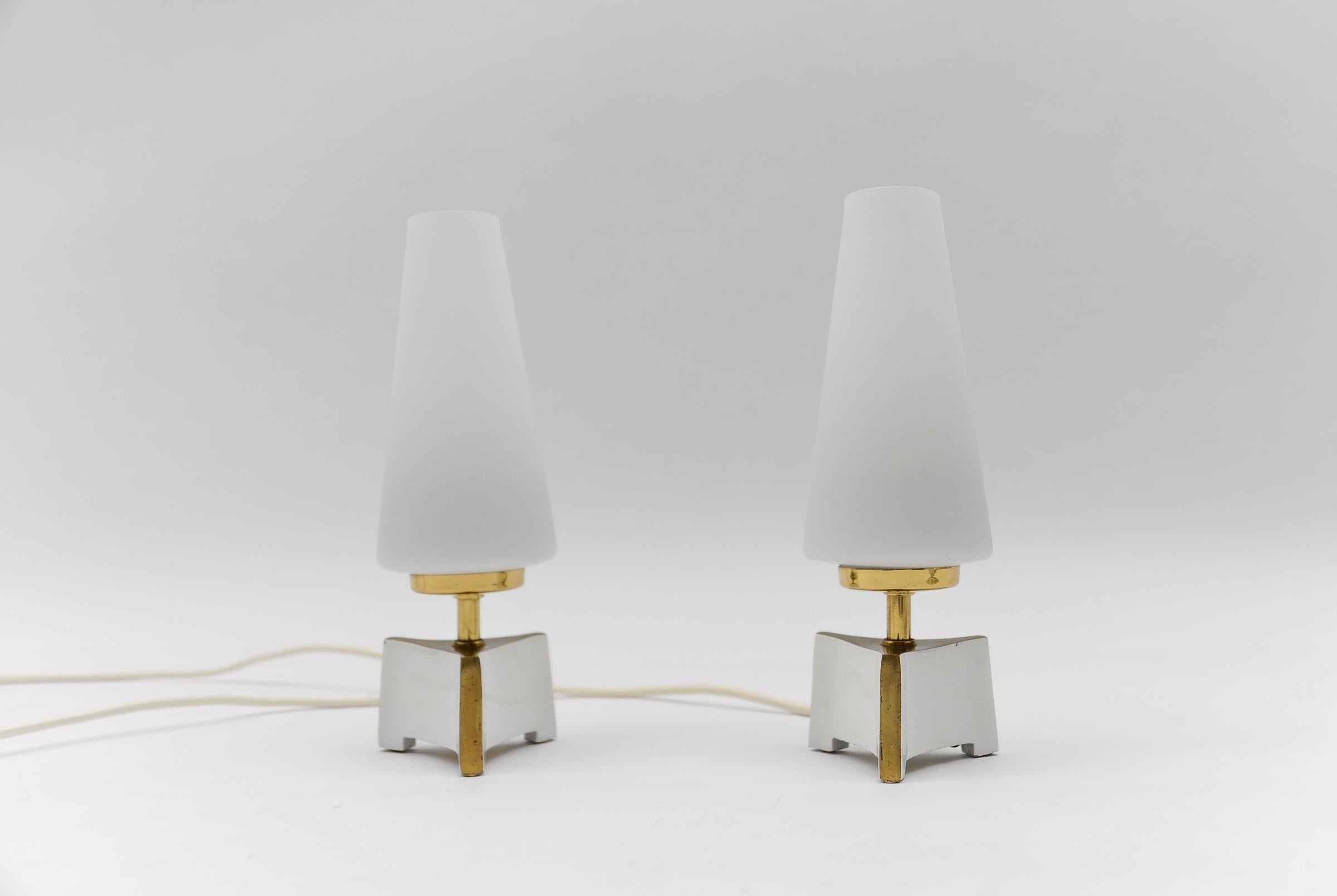 Petite Mid-Century Modern Massive Brass and Opaline Glass Table Lamps, 1950s

Dimension
Height: 9.05 in (23 cm)
Width: 3.14 in (8 cm)

Each lamp needs 1 x E14 Edison screw fit bulb, is wired, and in working condition. It runs both on 110 / 230