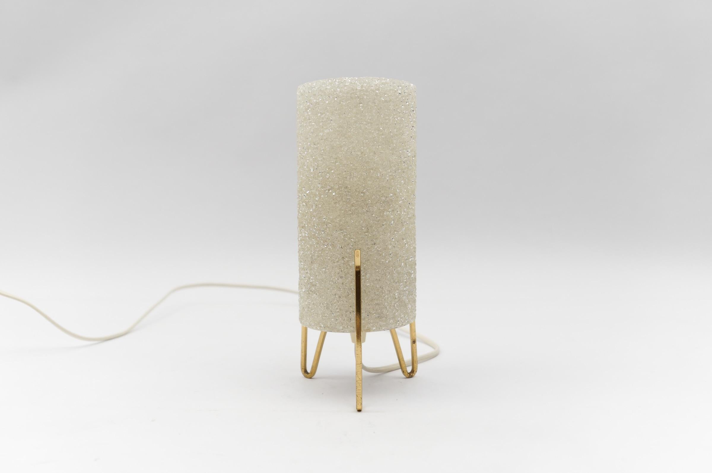 Petite Mid-Century Modern Tripod Table Lamp in Brass and Granulate, 1960s

Dimension
Height: 9.25 in (23,5 cm)
Width: 4.72 in (12 cm)

The lamp needs 1 x E14 / E15 Edison screw fit bulb, is wired, and in working condition. It runs both on 110 / 230
