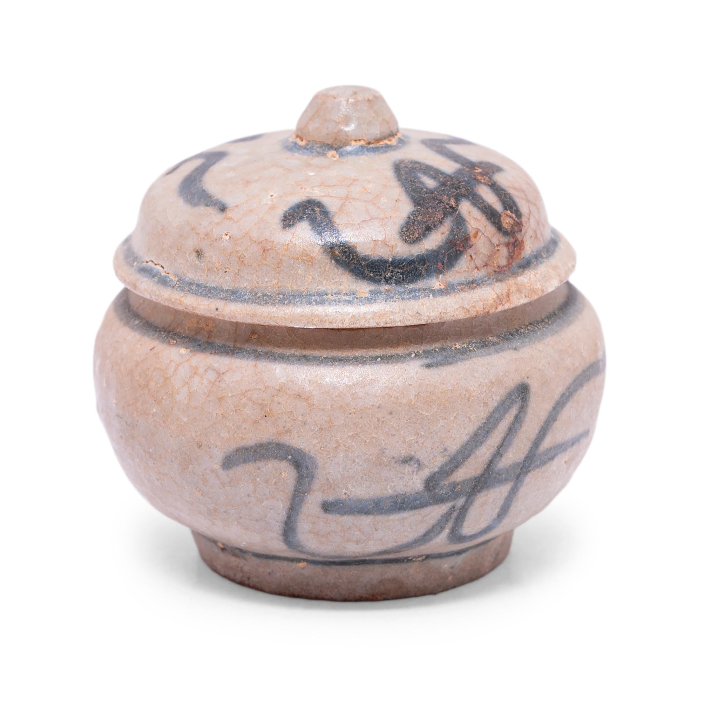 A charming example of provincial blue-and-white pottery, this petite lidded jar from the late Ming dynasty (1368-1644) is brushed with expressive sweeps of blue atop a cool white underglaze. Shaped with a round body and a simple domed lid, the