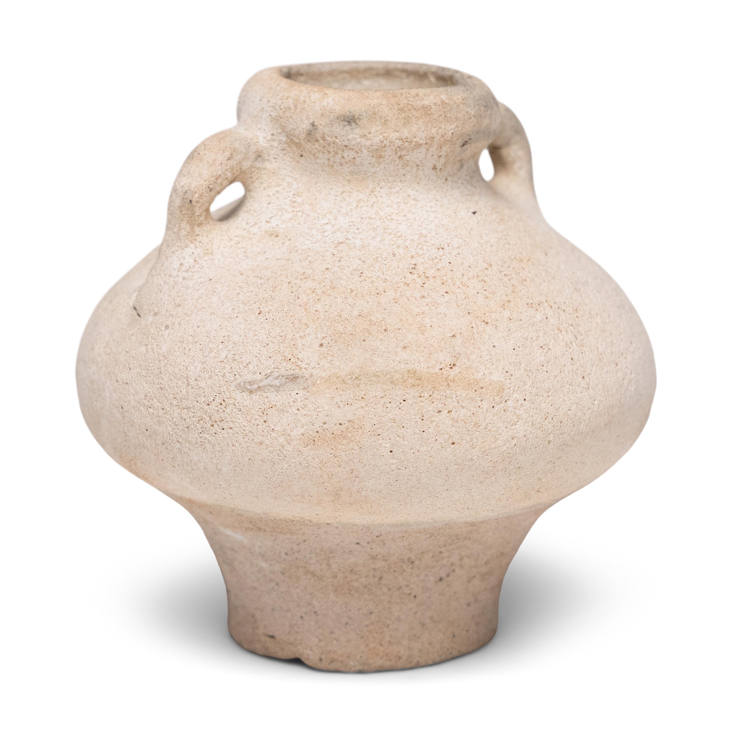 La superficie erosionada de este pequeño tarro medicinal de la dinastía Ming cuenta una historia de comercio, tradición y tesoros perdidos. La textura porosa y mate de la superficie sugiere que la tinaja pasó muchos años sumergida en agua salada,