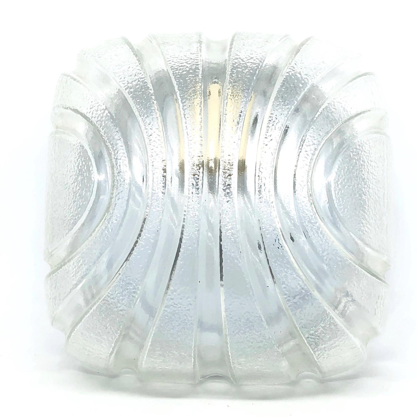 A petite gorgeous futuristic glass flush mount. It can be used also as a sconce. The light fixture requires one European E27 bulb, up to 60 watts. Clear ice glass, mounted on a white lacquered base.