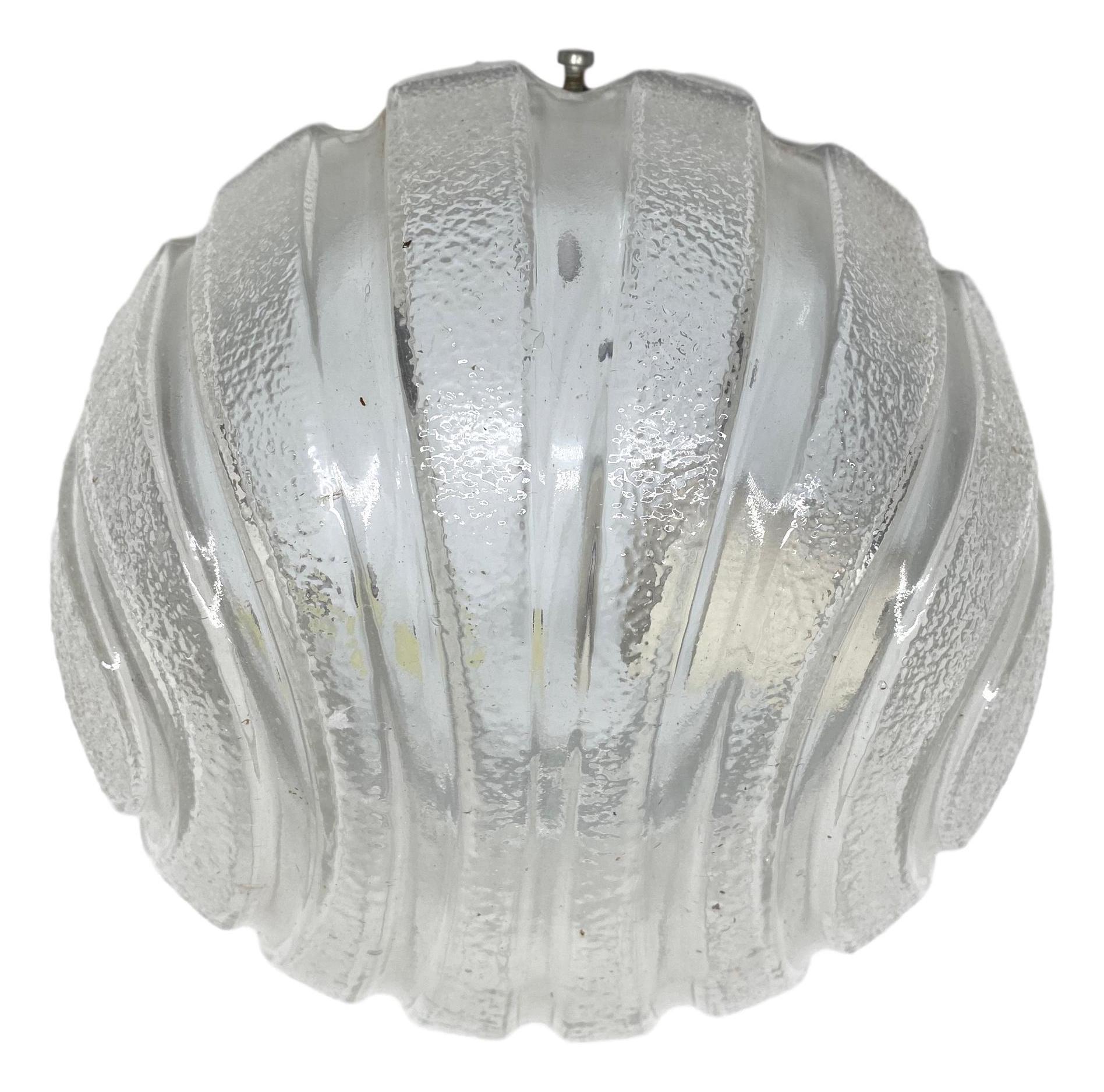 A petite gorgeous futuristic glass flush mount. It can be used also as a sconce. The light fixture requires one European E27 bulb, up to 60 watts. Clear ice glass, mounted on a white lacquered base.