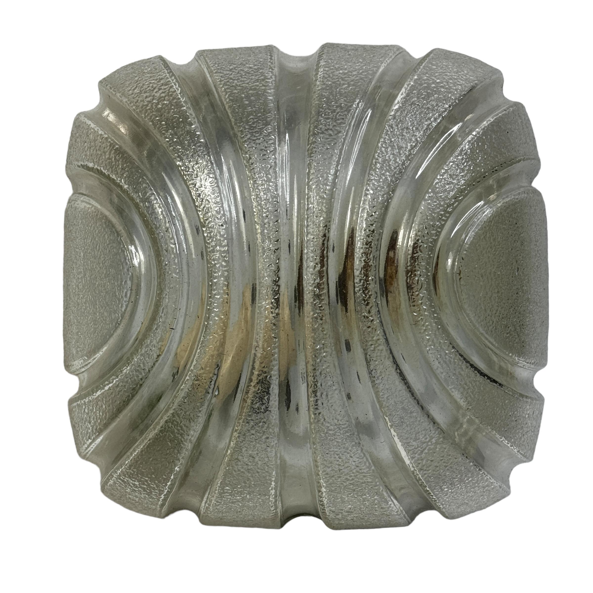 A petite gorgeous futuristic glass flush mount. It can be used also as a sconce. The light fixture requires one European E27 bulb, up to 60 watts. Clear ice glass, mounted on a lacquered base. A nice addition to any room. Found at an Estate Sale in